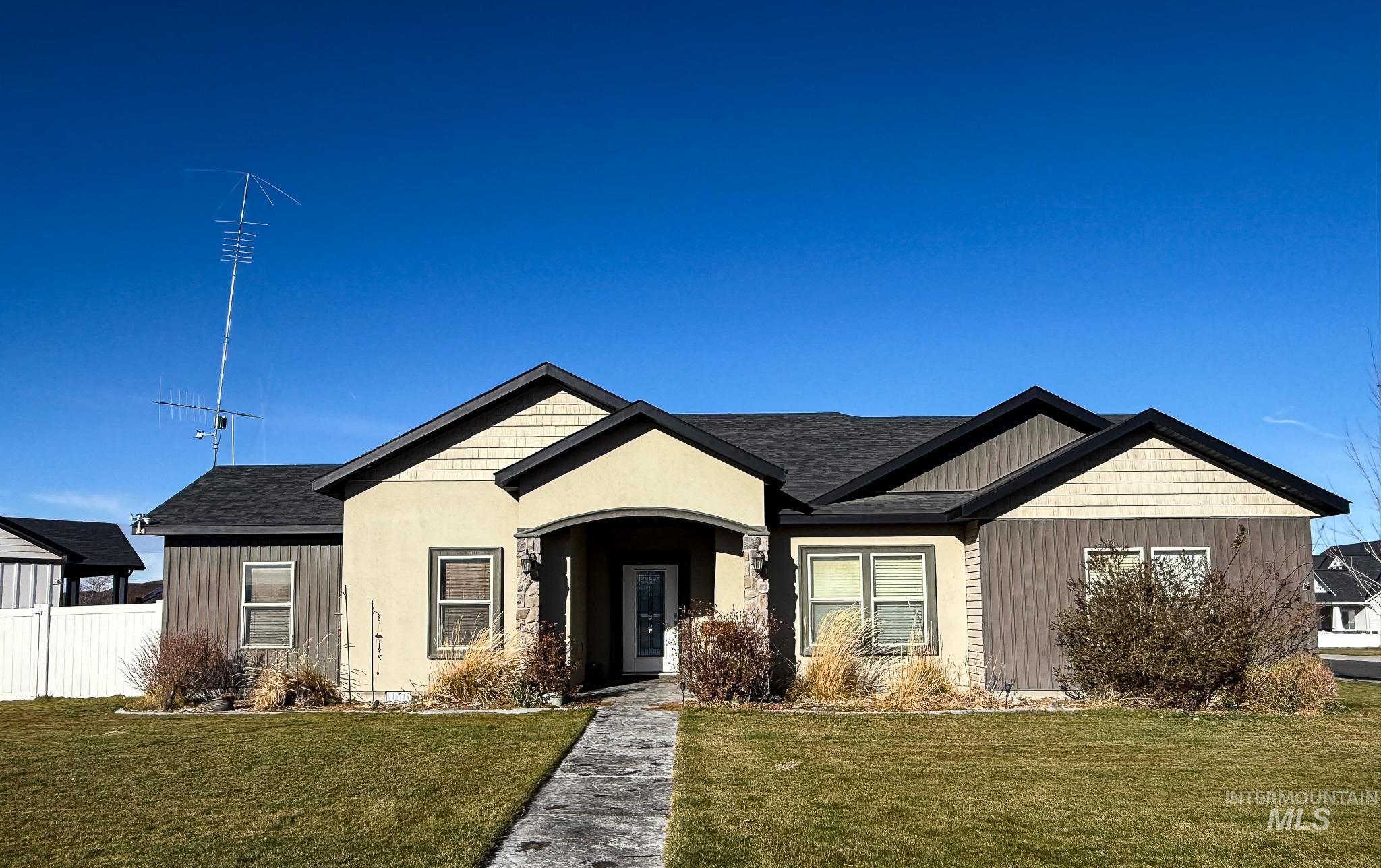View of front of house featuring a shingled roof and stucco siding