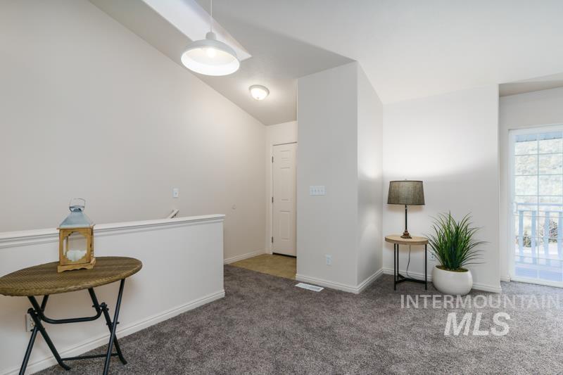 Living area with carpet and an upstairs landing