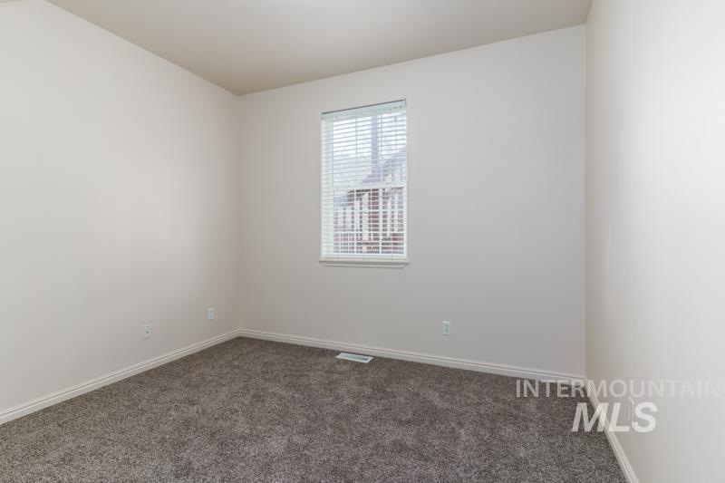 Carpeted spare room with baseboards