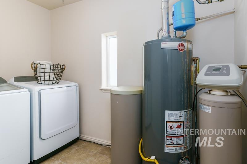 Utility room featuring washer and clothes dryer and gas water heater