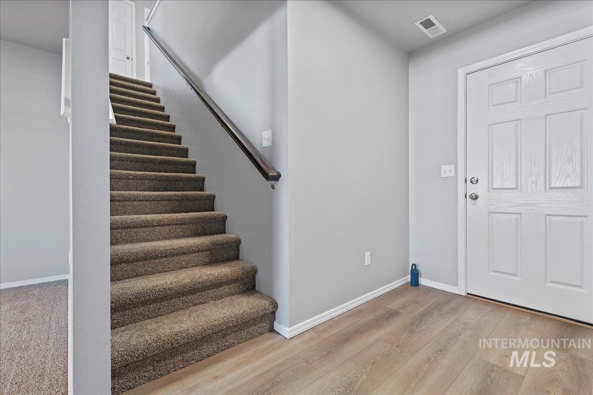 Entrance foyer with light wood-type flooring and stairs