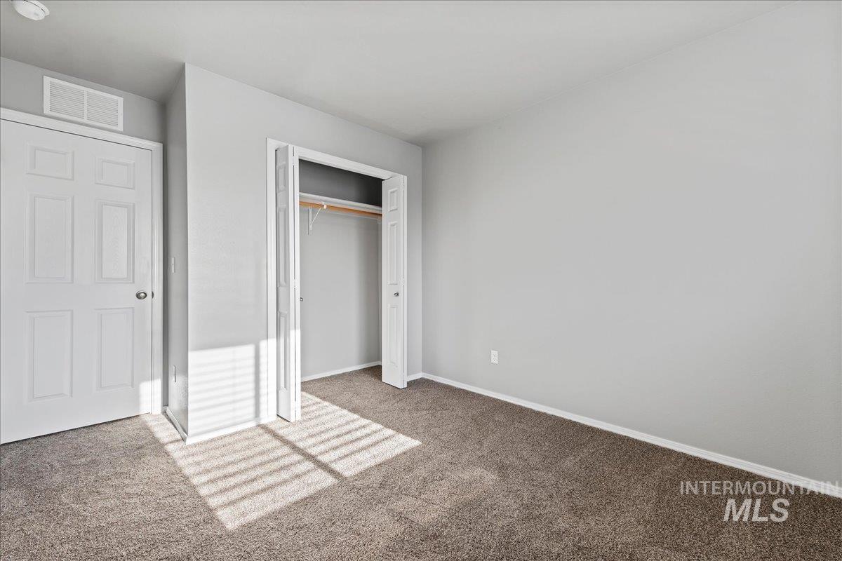 Unfurnished bedroom with carpet and a closet