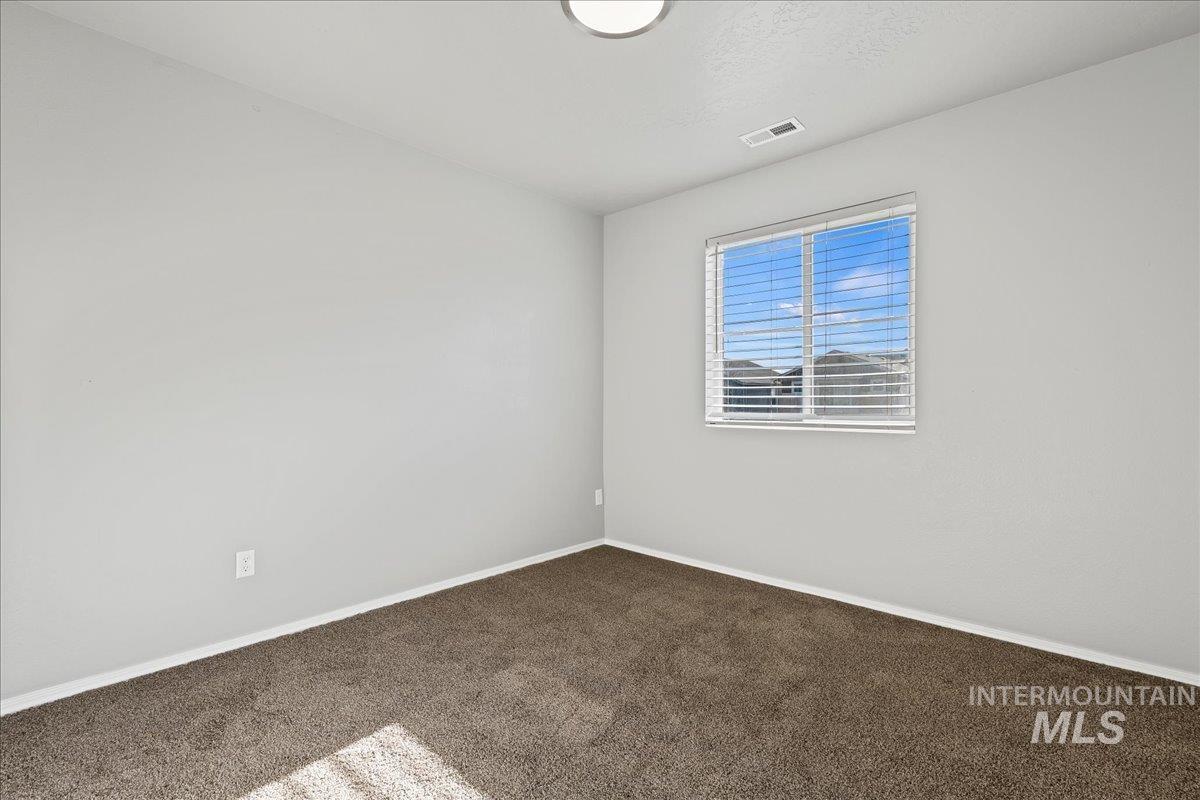 Empty room featuring carpet flooring and baseboards