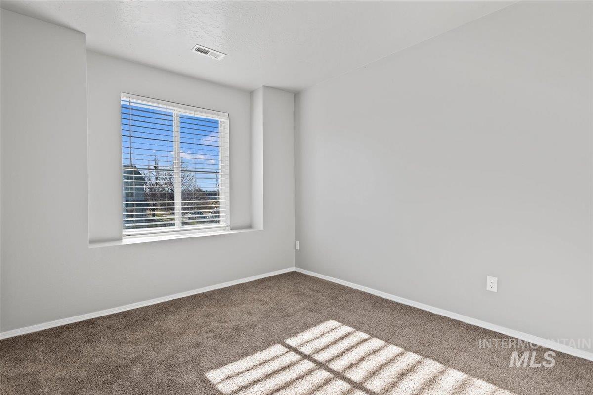 Spare room featuring carpet flooring and a textured ceiling