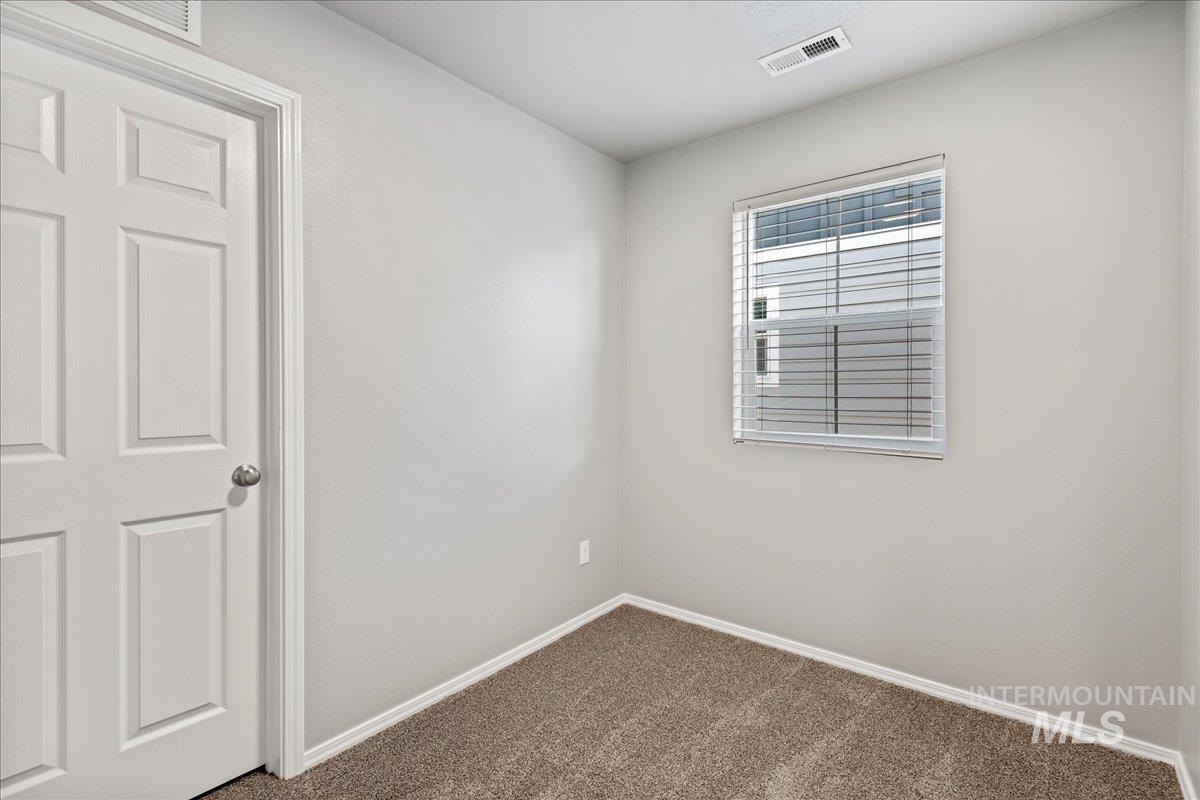 Carpeted empty room with baseboards