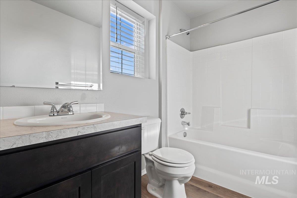 Bathroom with vanity, tub / shower combination, and wood finished floors