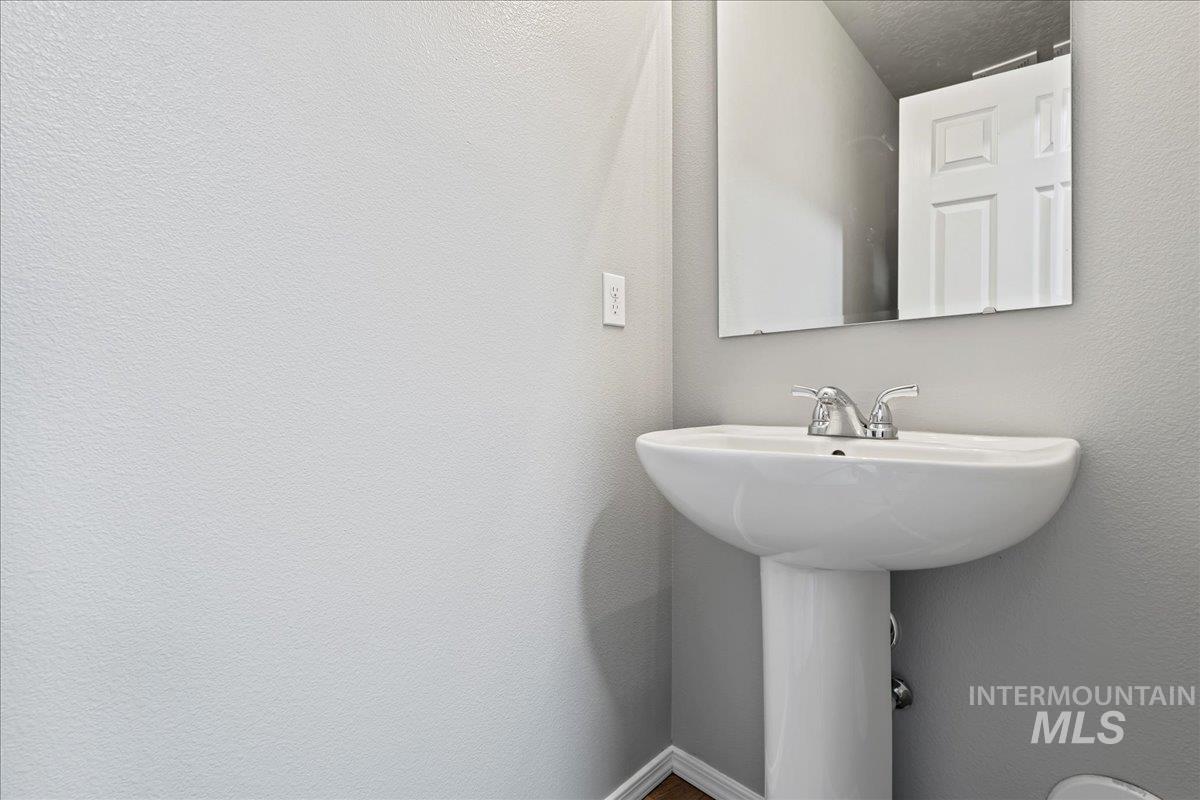 Bathroom with a textured wall and baseboards