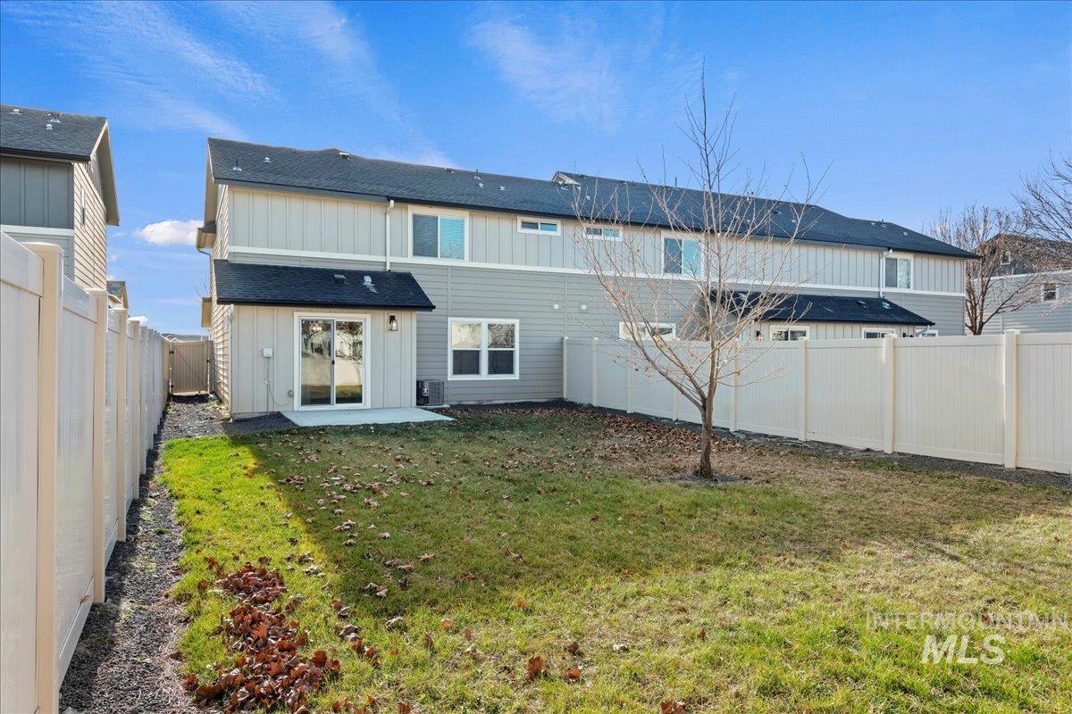 Back of property featuring a fenced backyard, a patio area, and board and batten siding