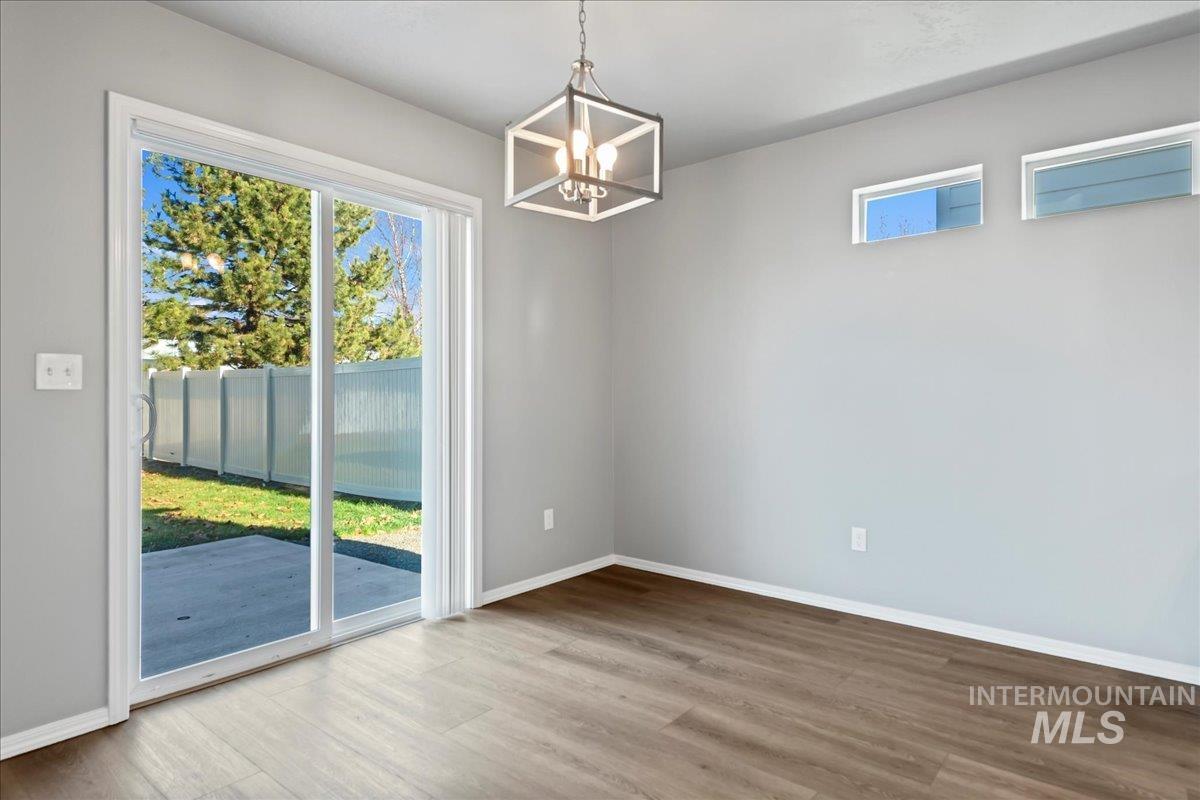 Unfurnished dining area with a chandelier and wood finished floors
