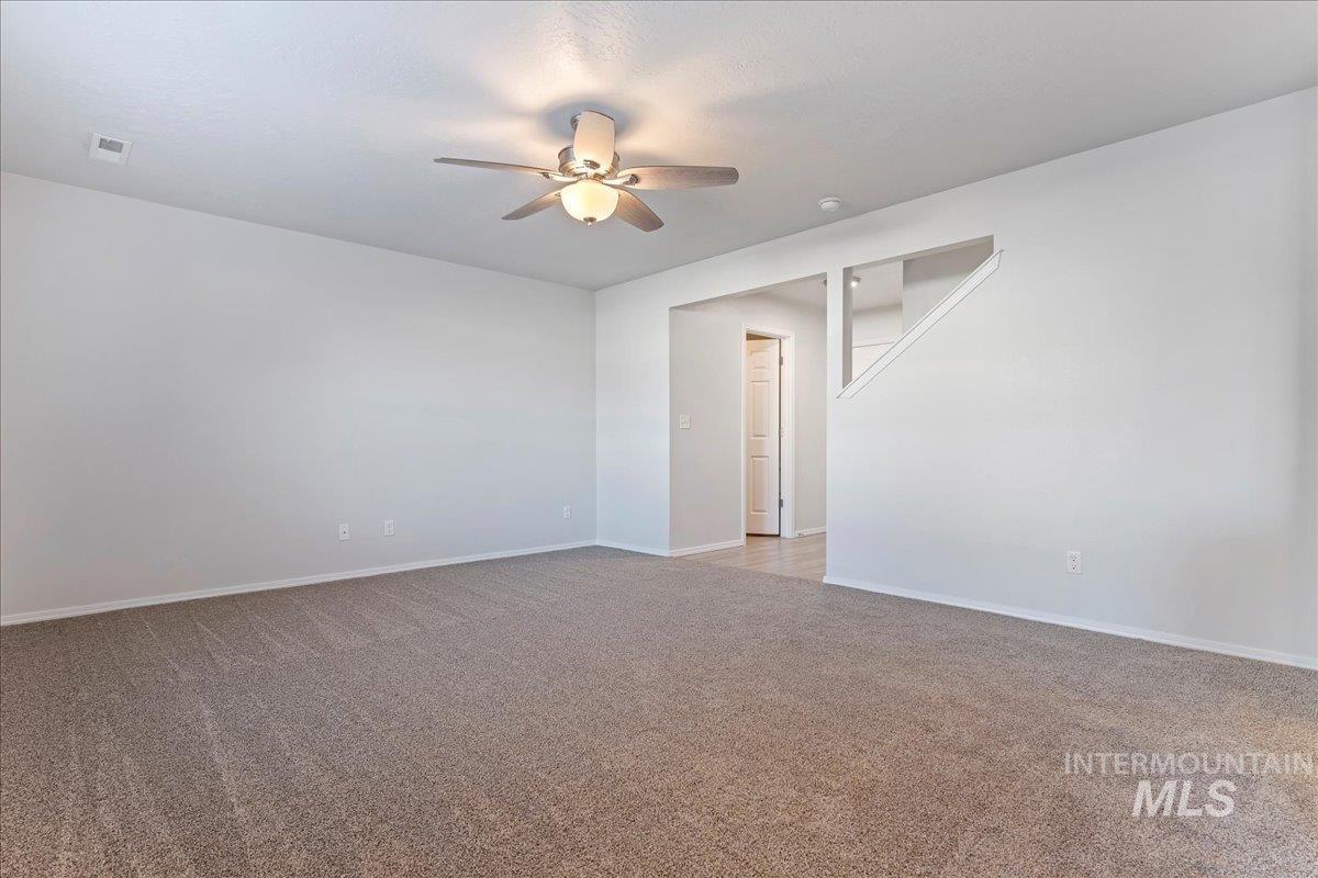 Spare room with light carpet and ceiling fan