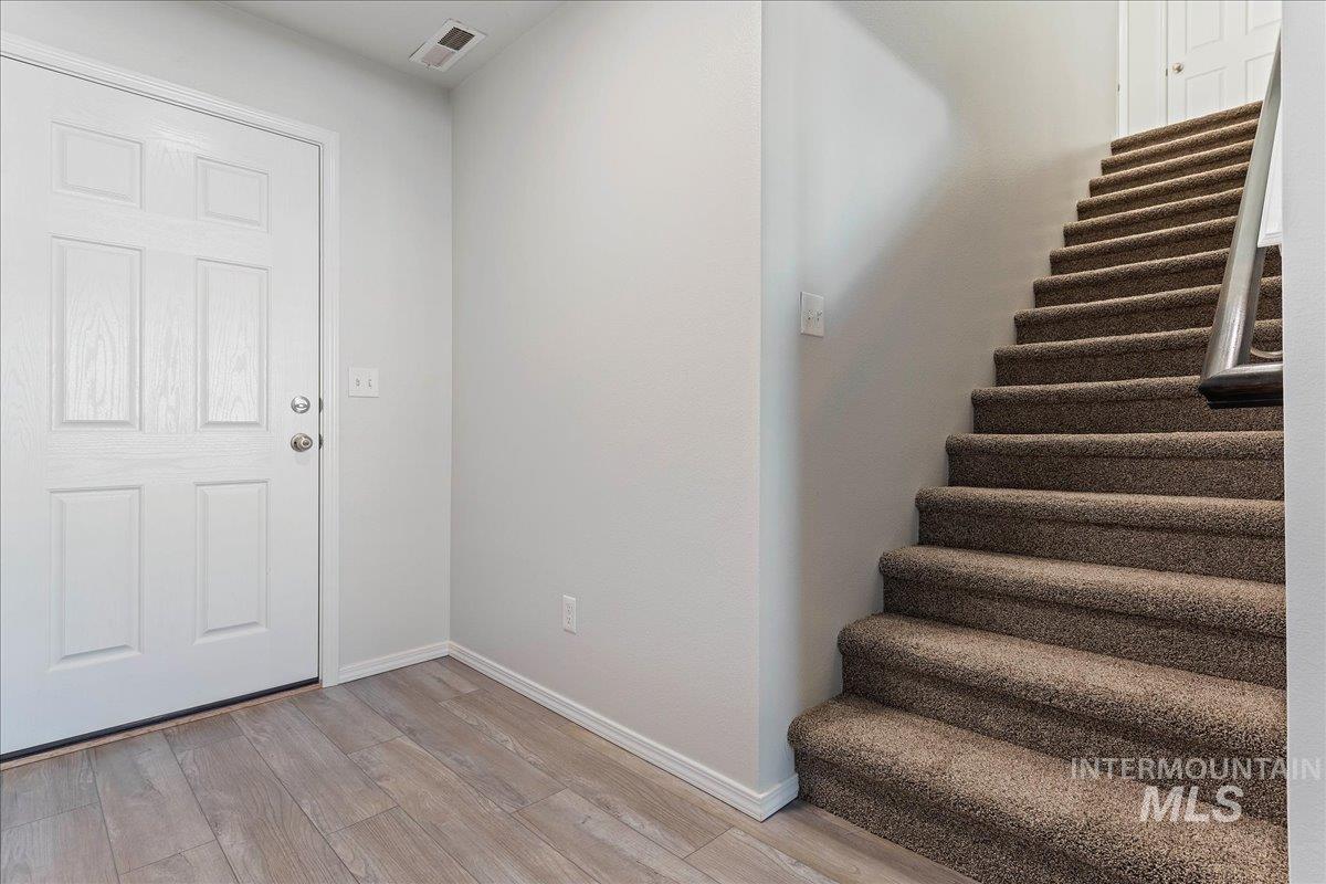 Foyer entrance with light wood-type flooring and stairway