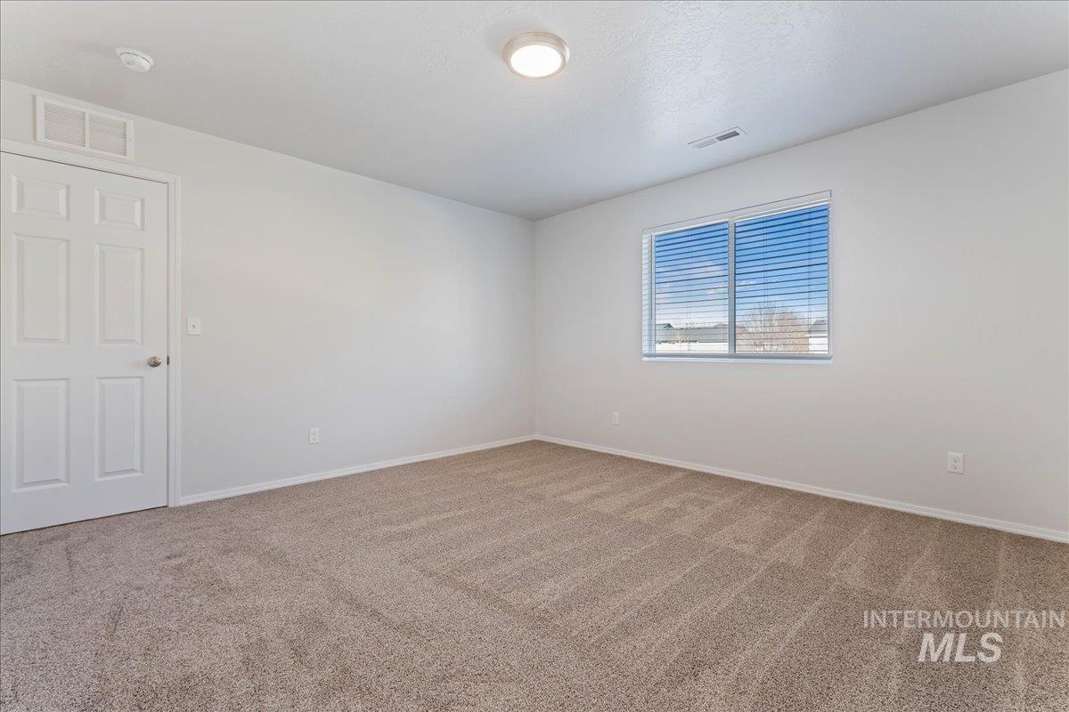 Empty room with light carpet and baseboards