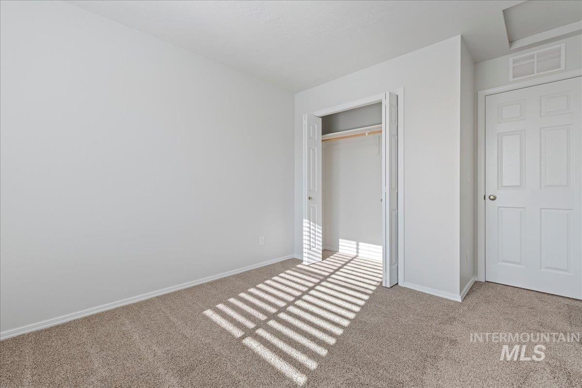 Unfurnished bedroom with light colored carpet and a closet
