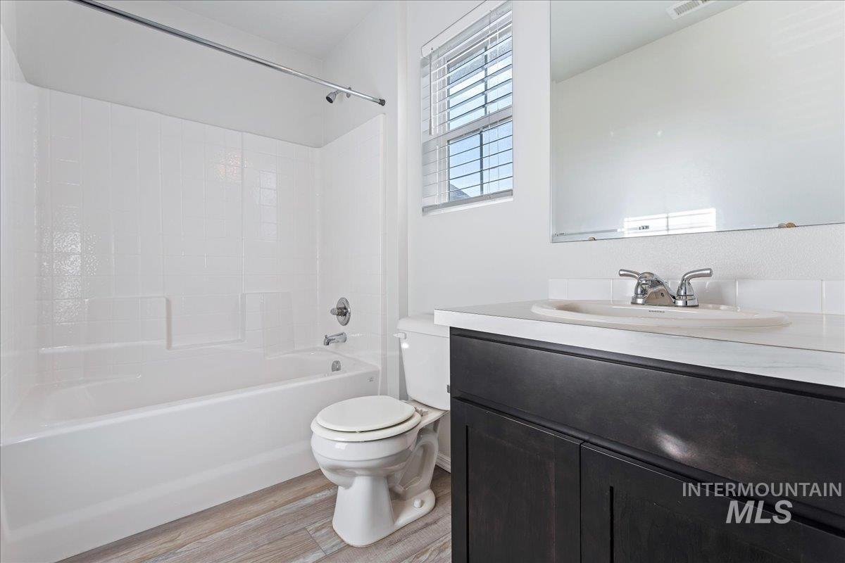 Full bathroom featuring vanity,  shower combination, and light wood-style floors