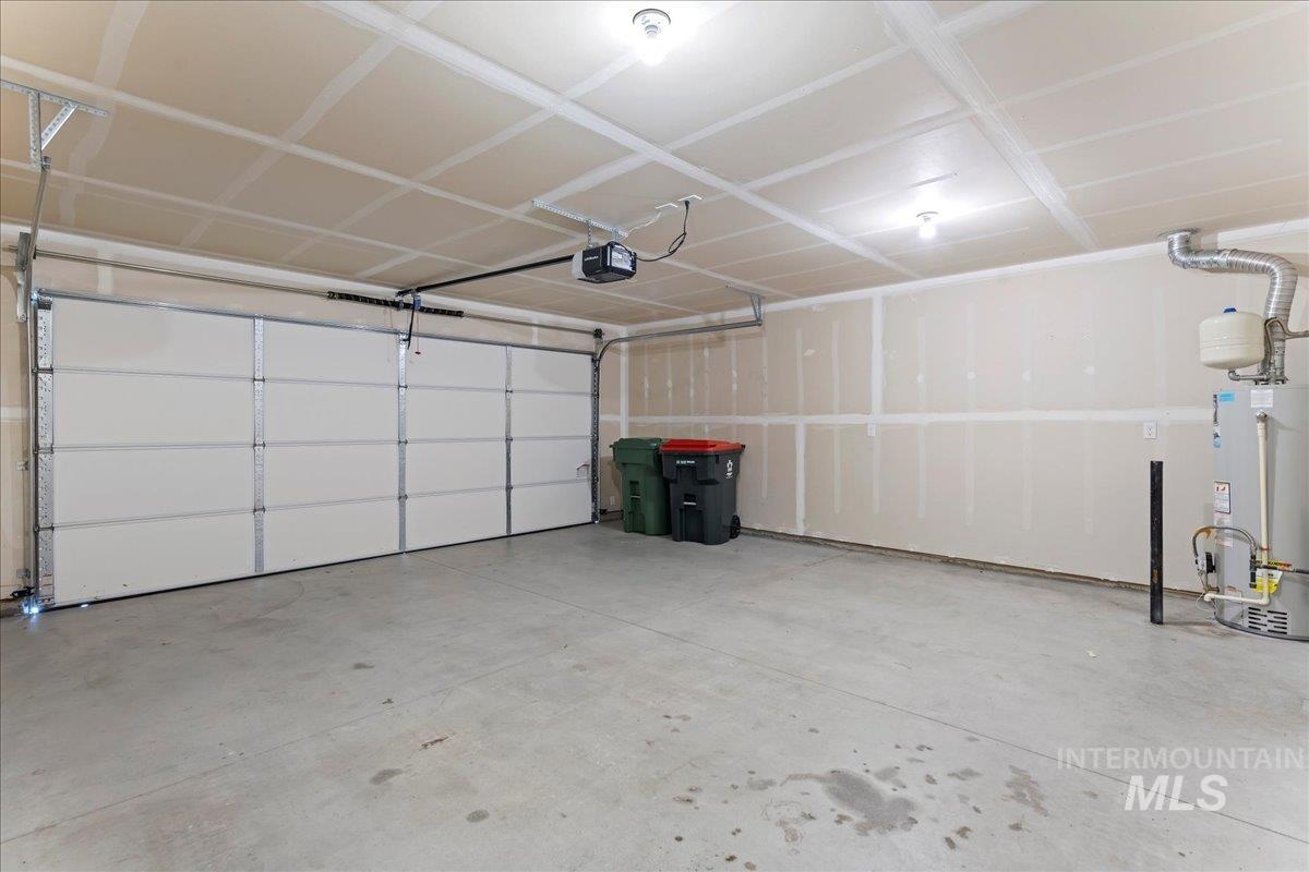 Garage featuring water heater and a garage door opener