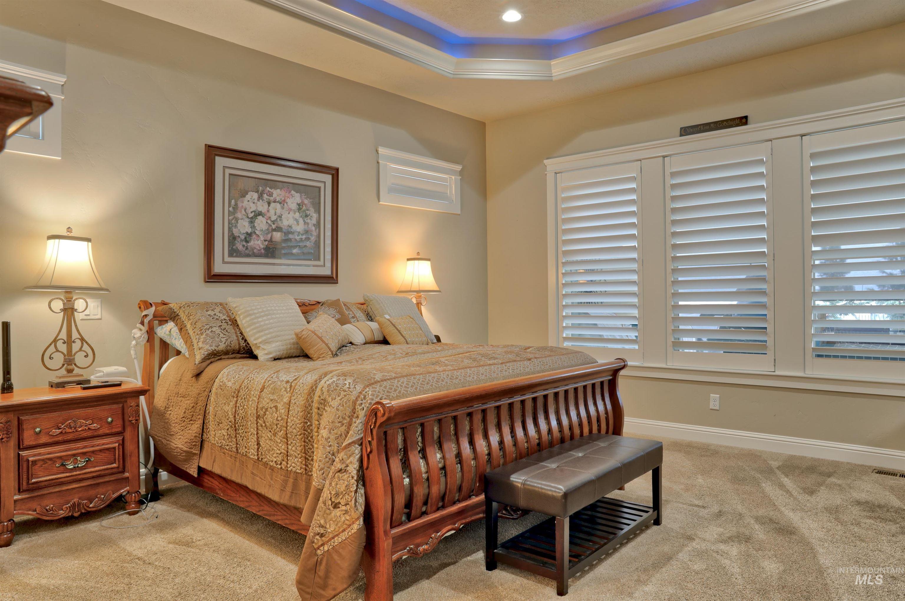 Bedroom featuring carpet flooring, crown molding, a raised ceiling, and recessed lighting