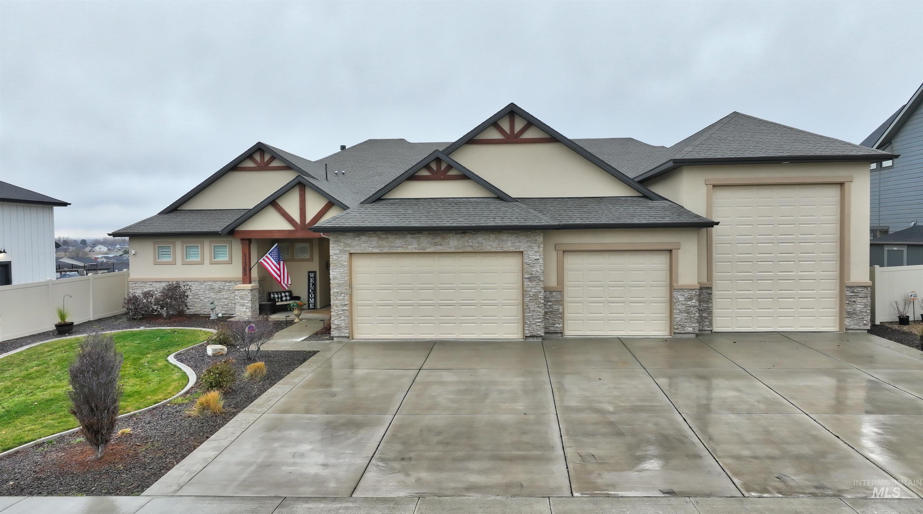 View of front of home featuring a shingled roof, an attached garage, stucco siding, and driveway