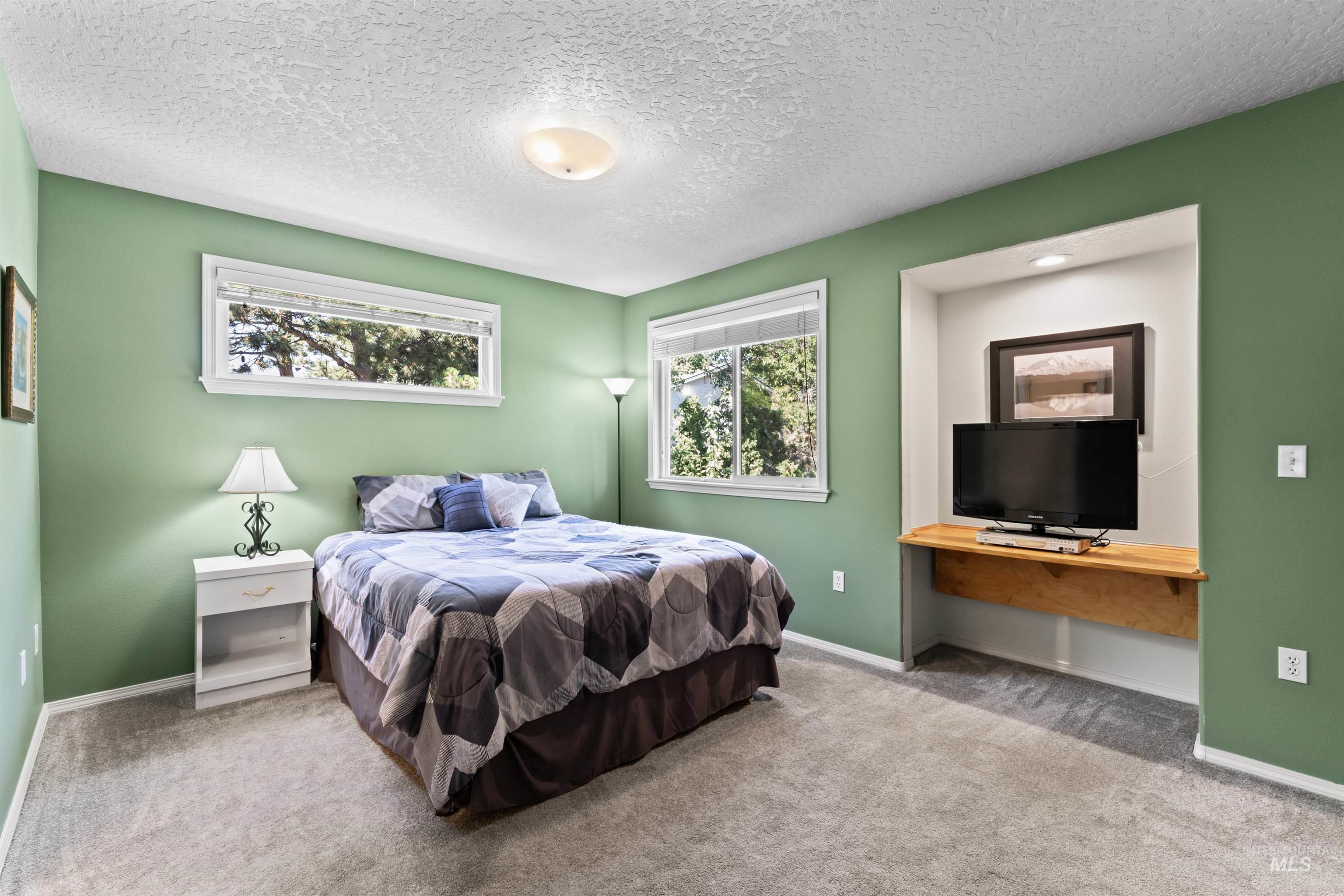Bedroom with carpet floors and a textured ceiling