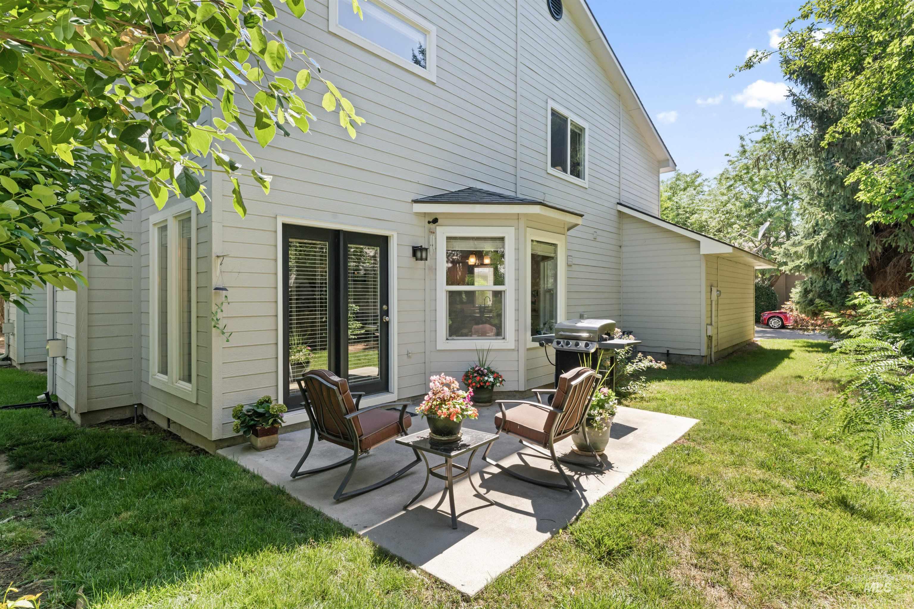 Back of property featuring a patio, a lawn, and an outdoor hangout area