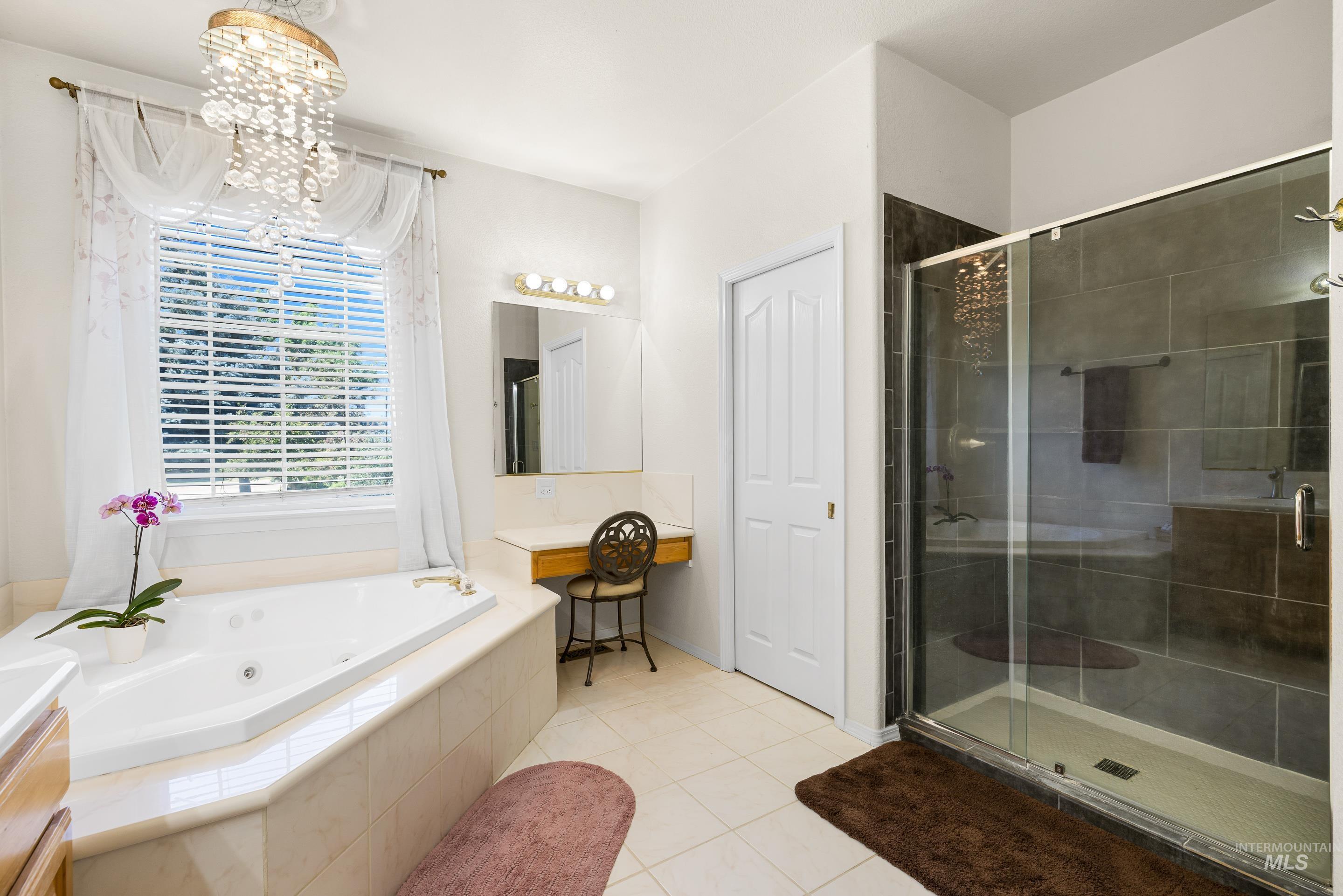 Bathroom with vanity, light tile patterned flooring, a shower stall, and a tub with jets