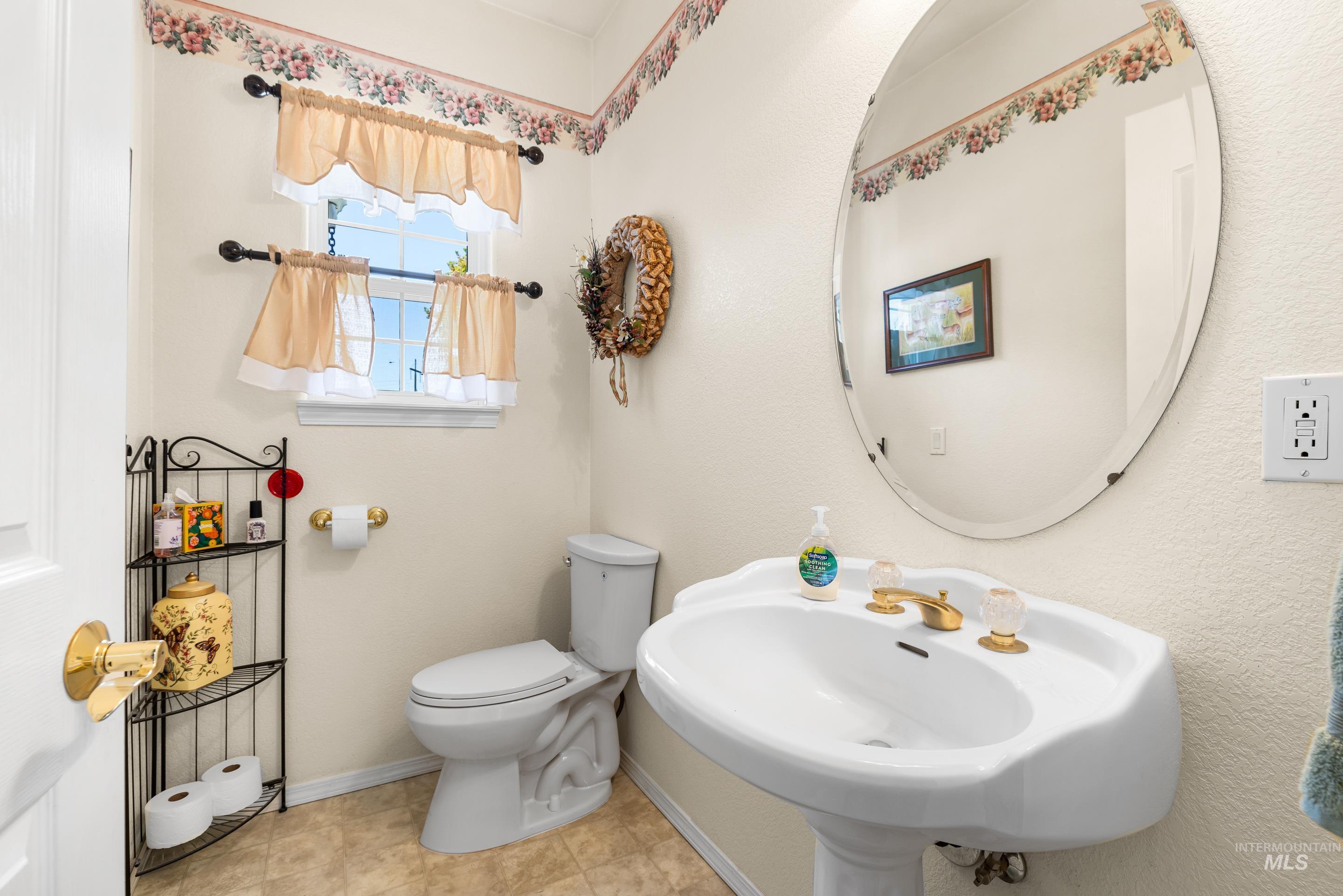 Half bathroom with baseboards and light tile patterned floors