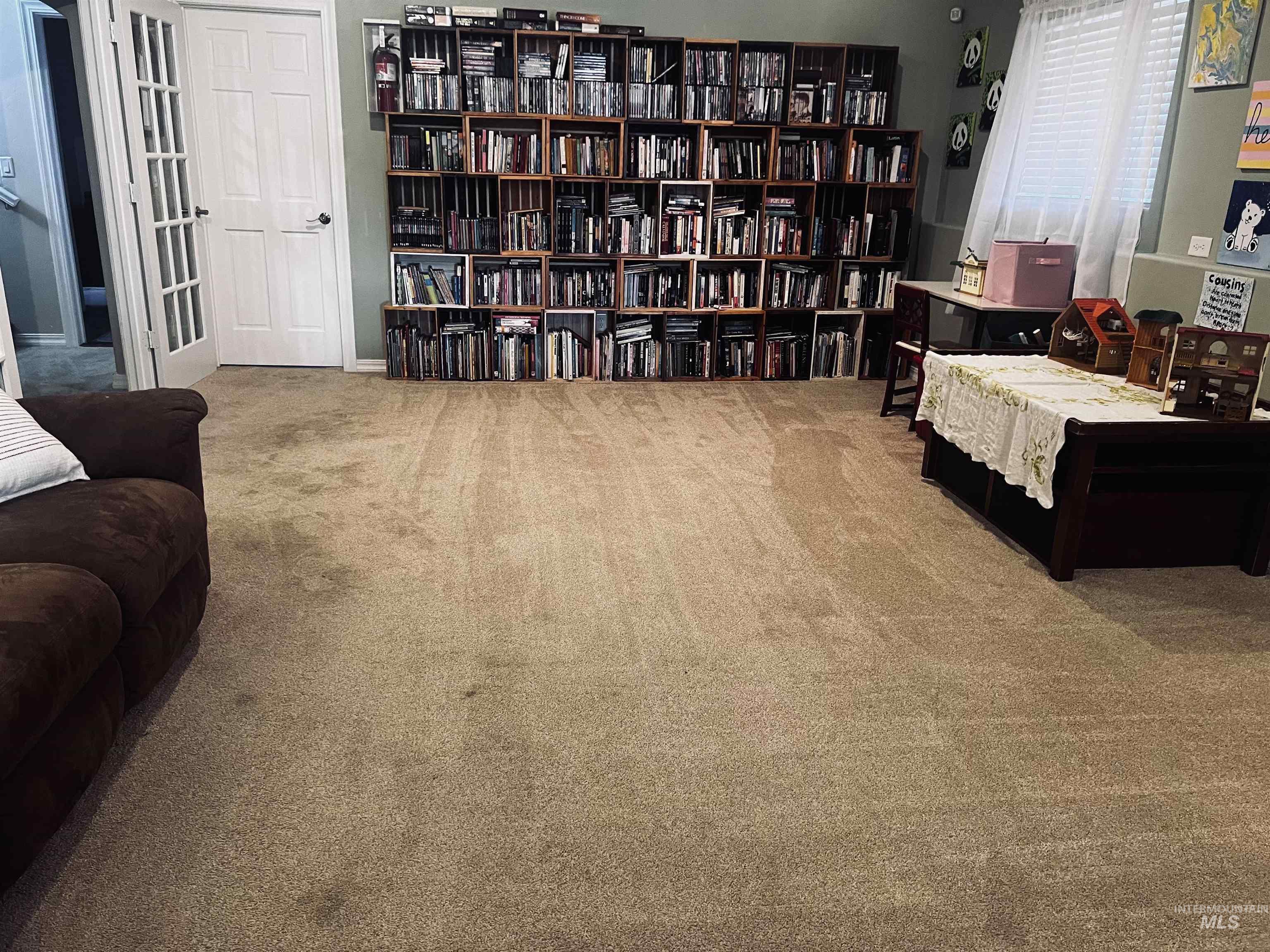 Living area featuring carpet and wall of books