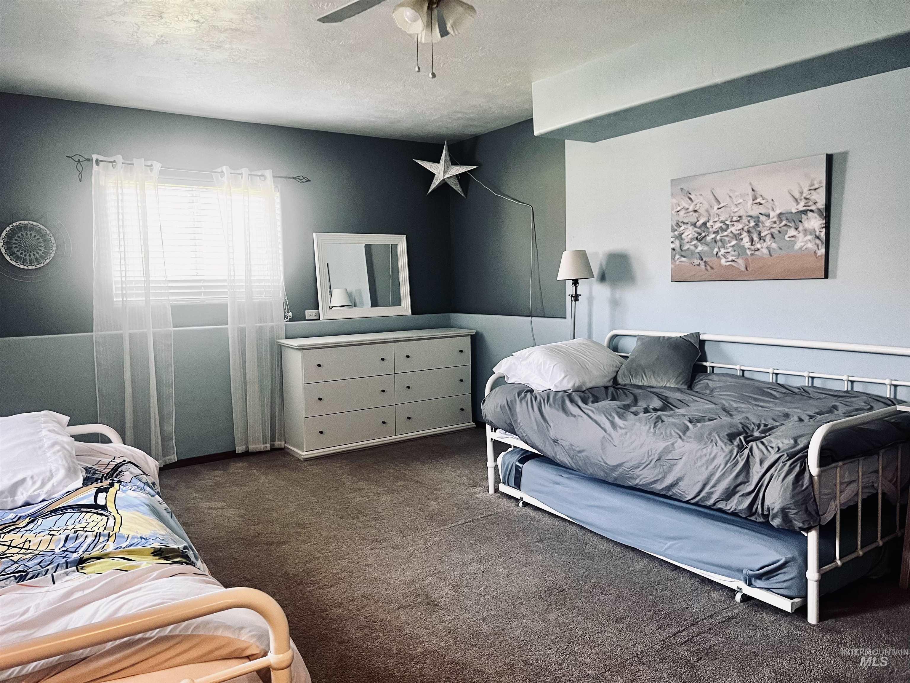 Bedroom featuring carpet floors, ceiling fan, and a textured ceiling