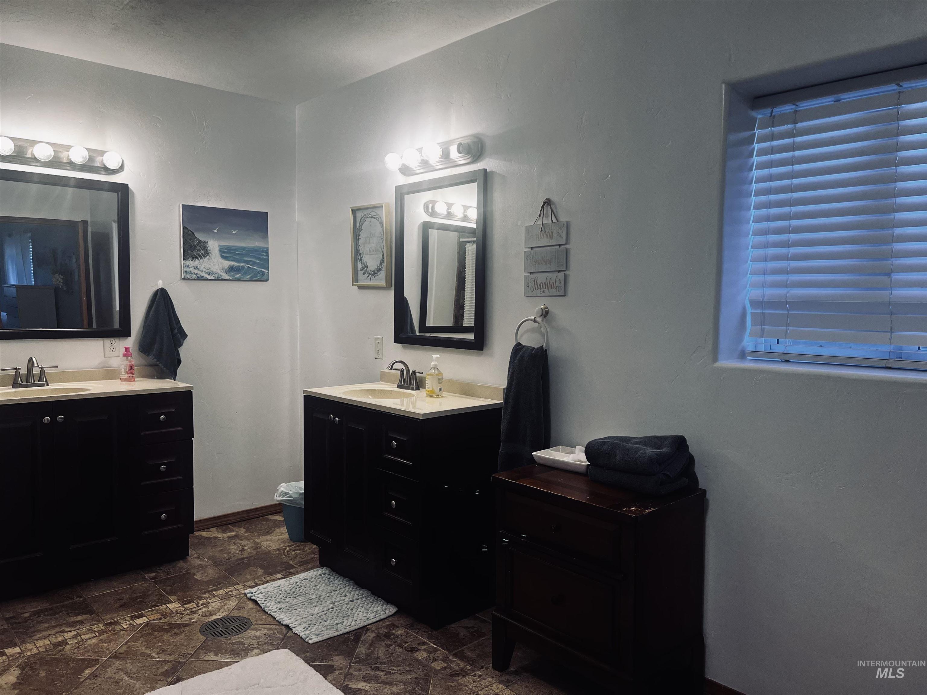 Bathroom with two vanities and stone tile flooring