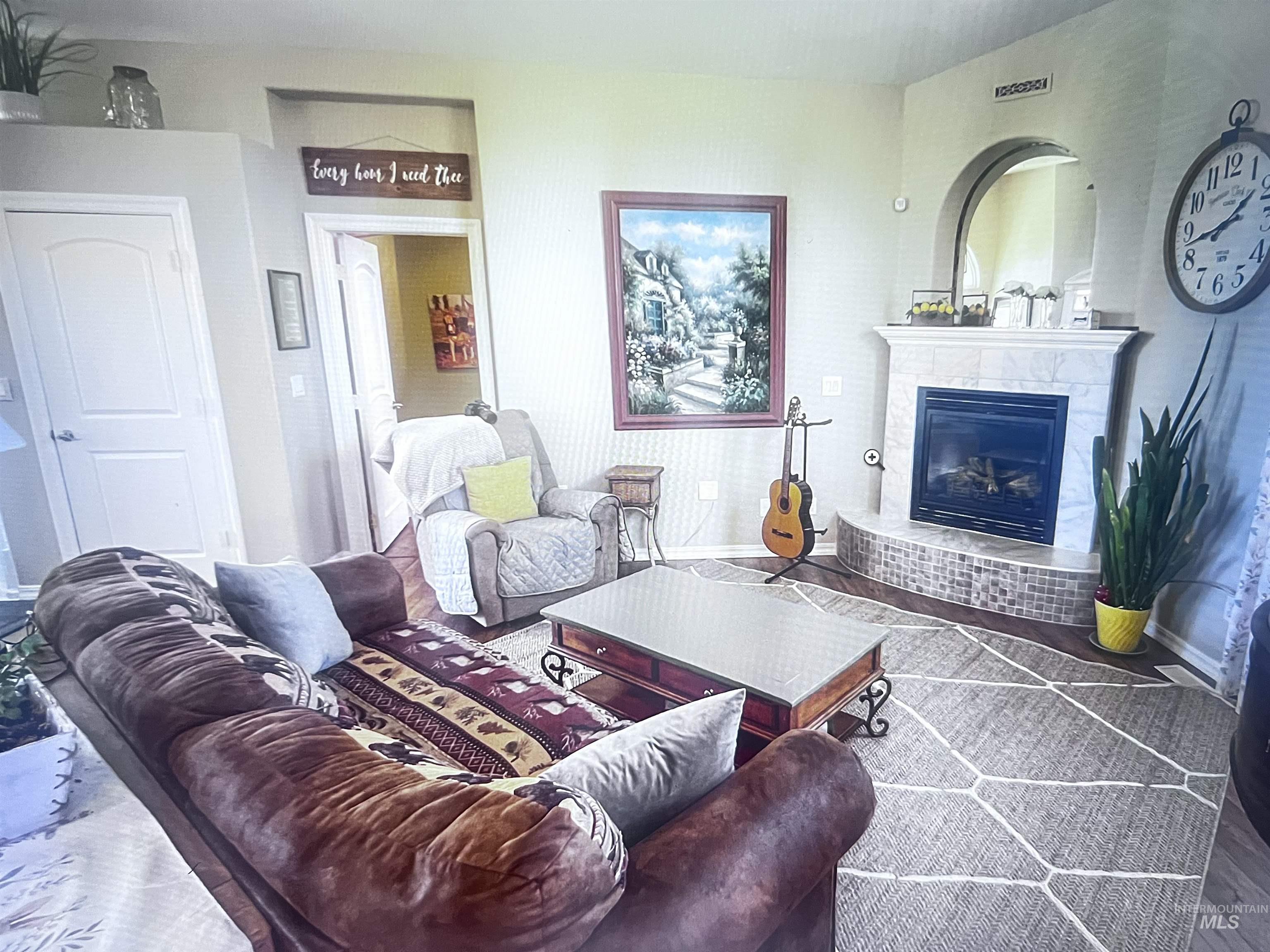 Living area with a glass covered fireplace and baseboards