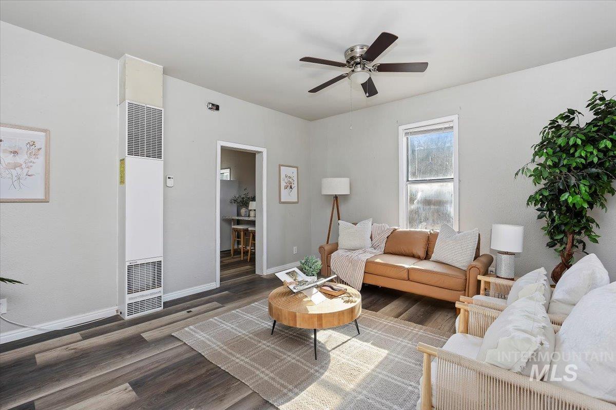Living room featuring a heating unit, wood finished floors, and a ceiling fan