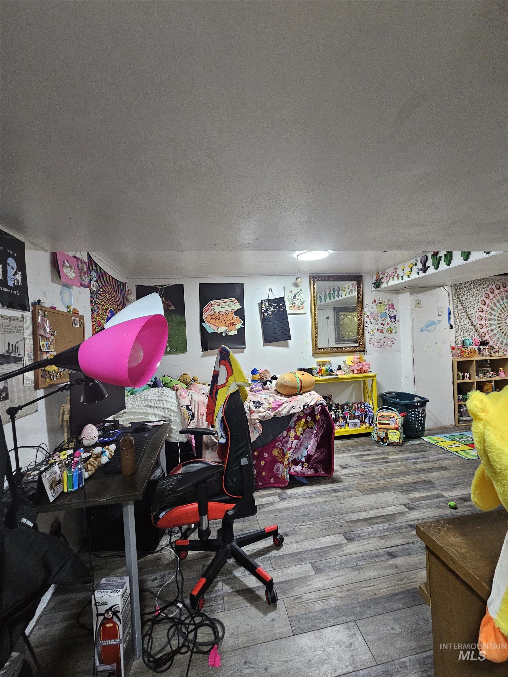 Game room featuring a textured ceiling, wood finished floors, and a desk