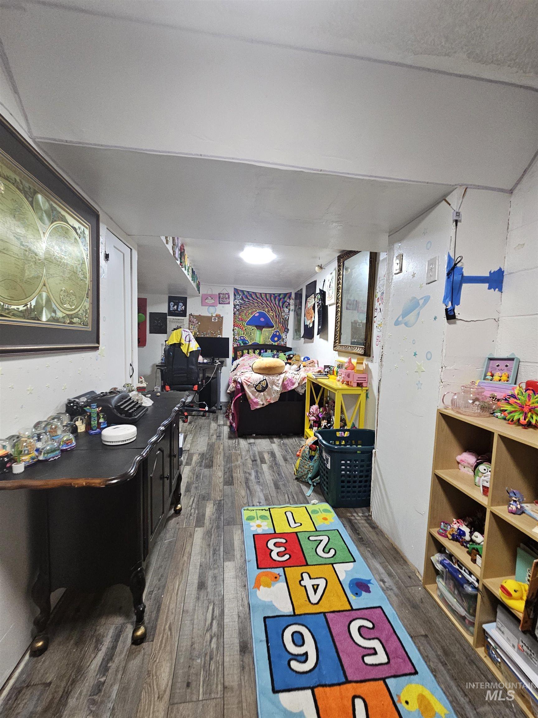 Game room featuring dark wood-style flooring