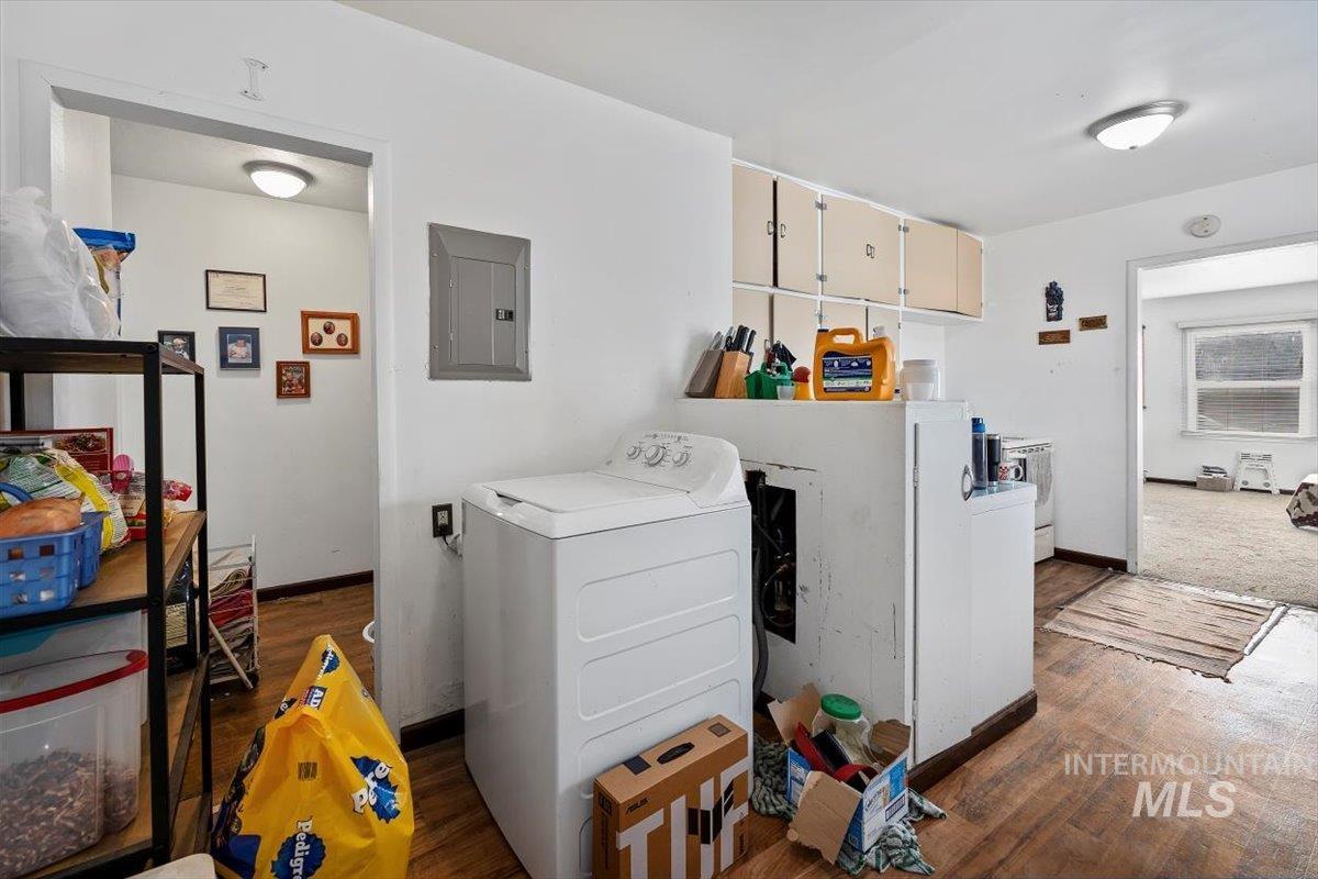 Laundry area featuring washer / clothes dryer, electric panel, and dark wood finished floors
