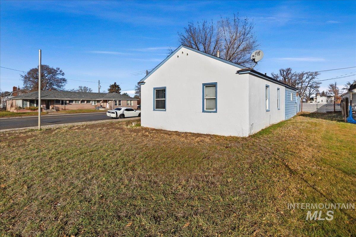View of side of home featuring a yard and stucco siding