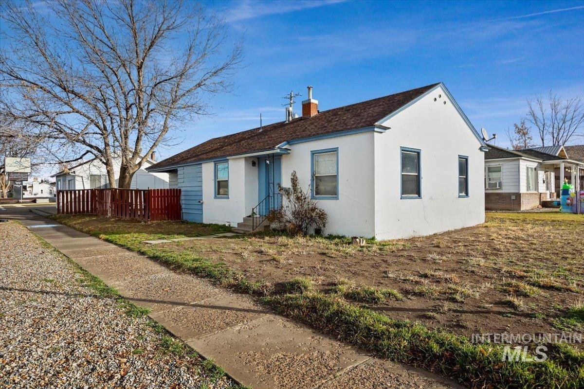 View of front of house featuring stucco siding and a chimney