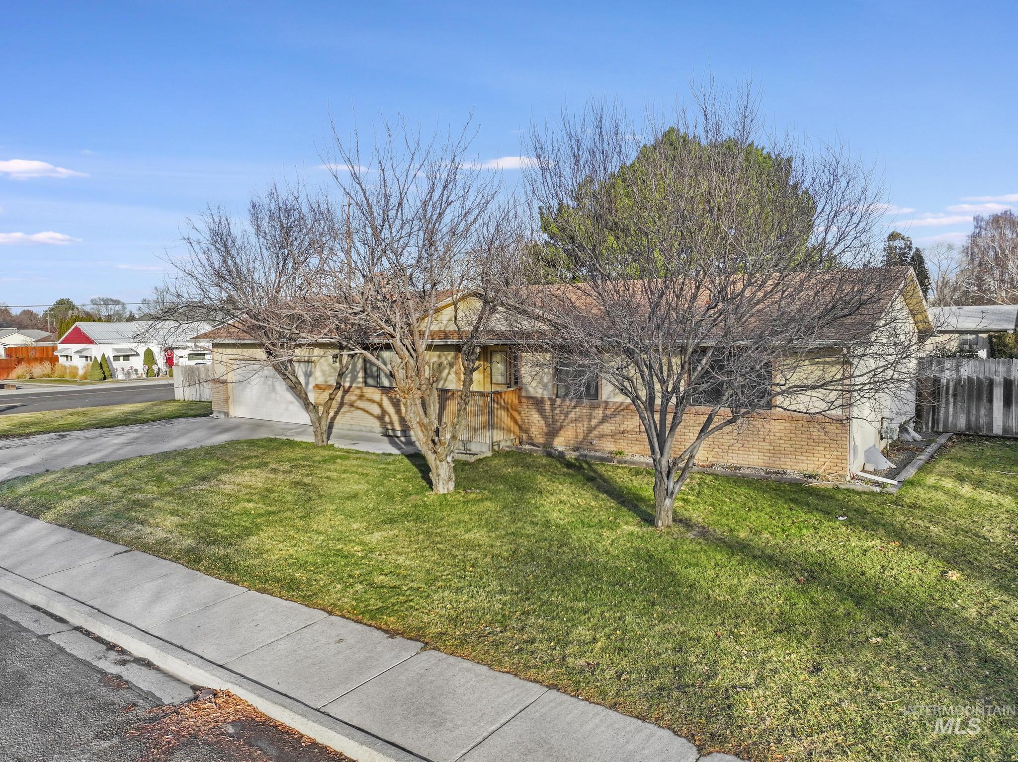 Single story home with driveway, a residential view, and brick siding