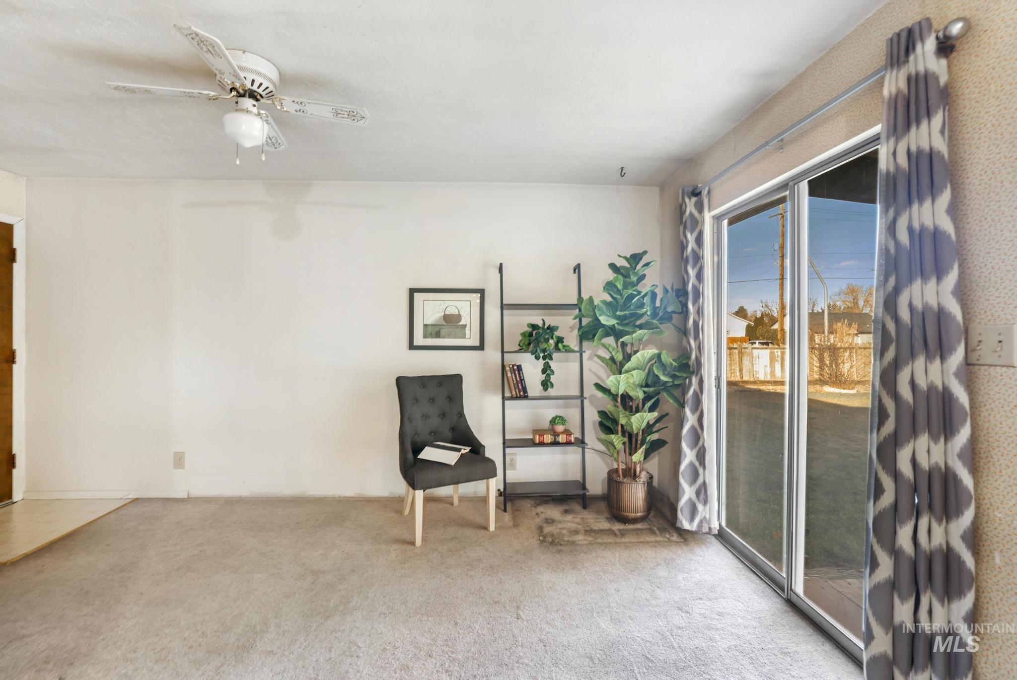 Living area with carpet floors and a ceiling fan