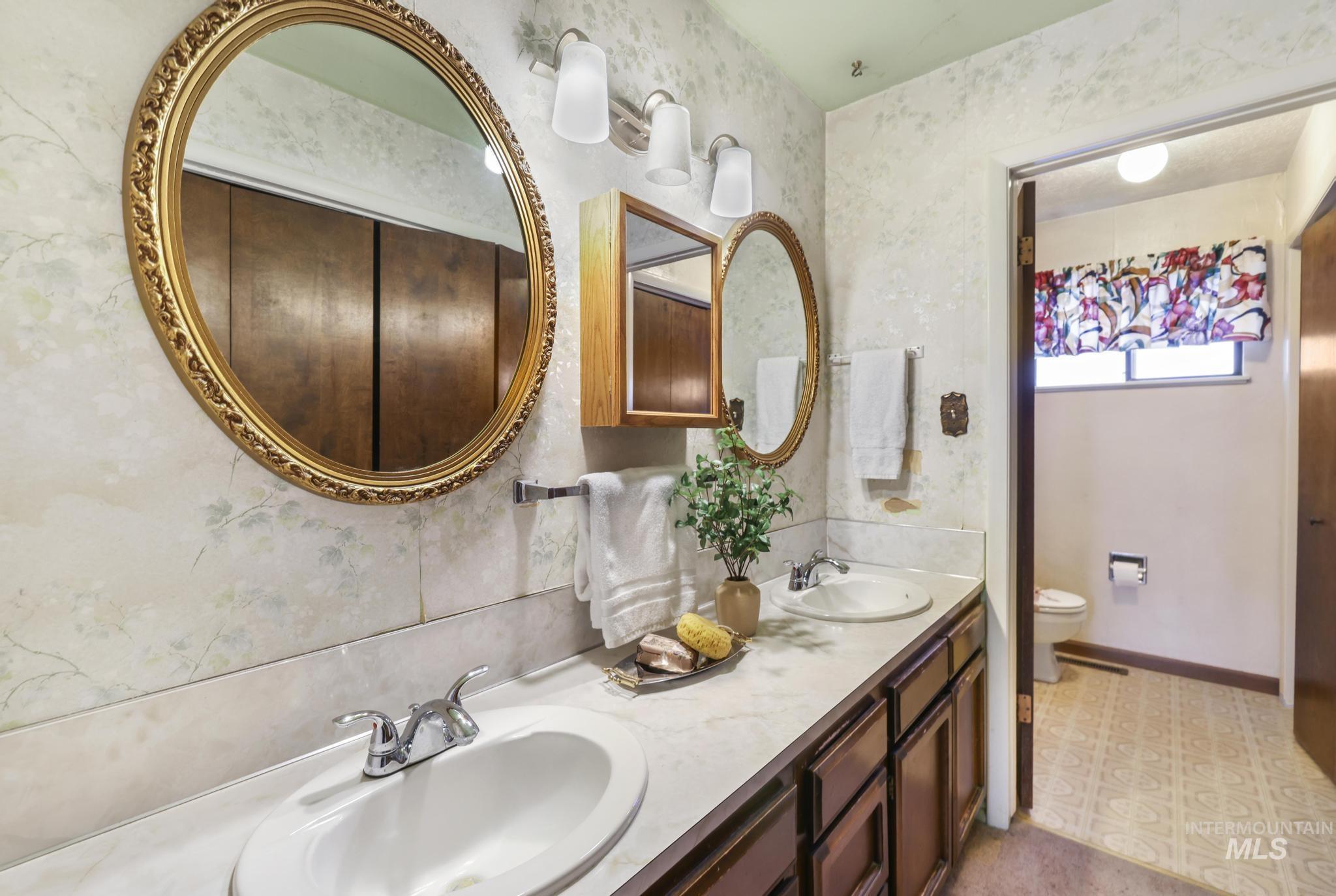 Full bathroom with double vanity and light floors