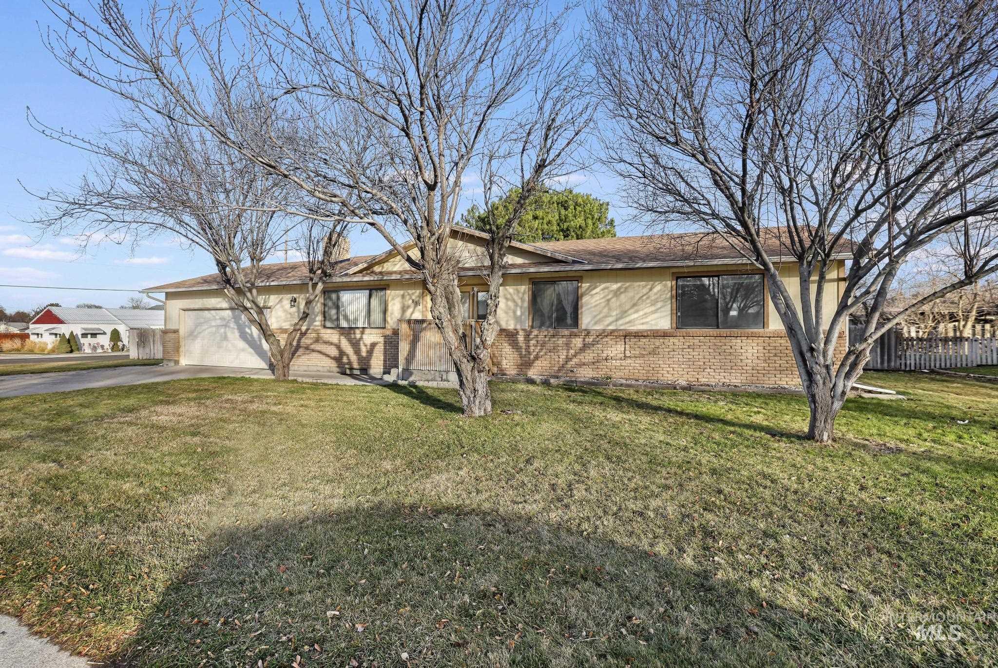 Single story home with brick siding, concrete driveway, and an attached garage