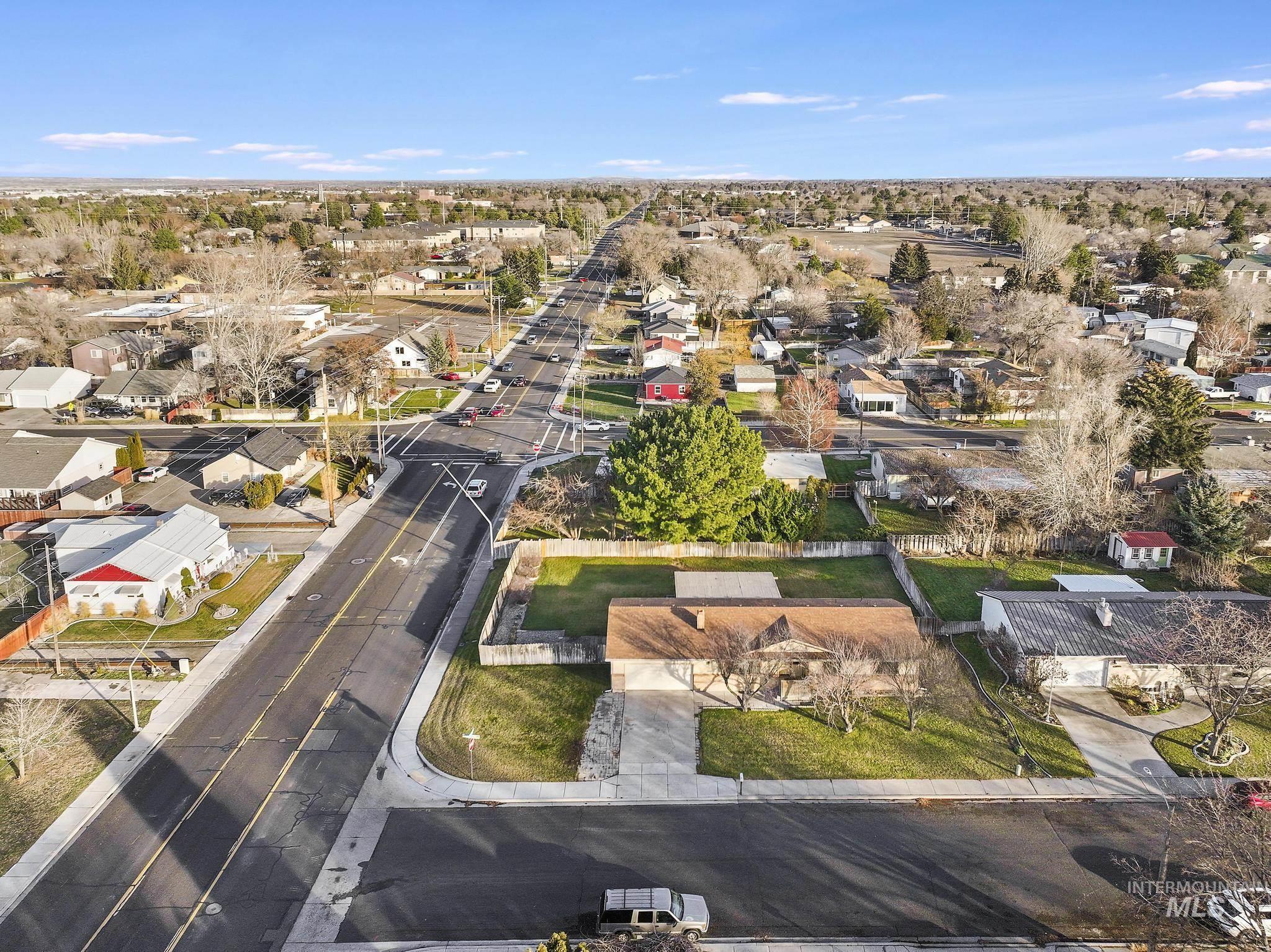 Aerial view of property and surrounding area featuring nearby suburban area