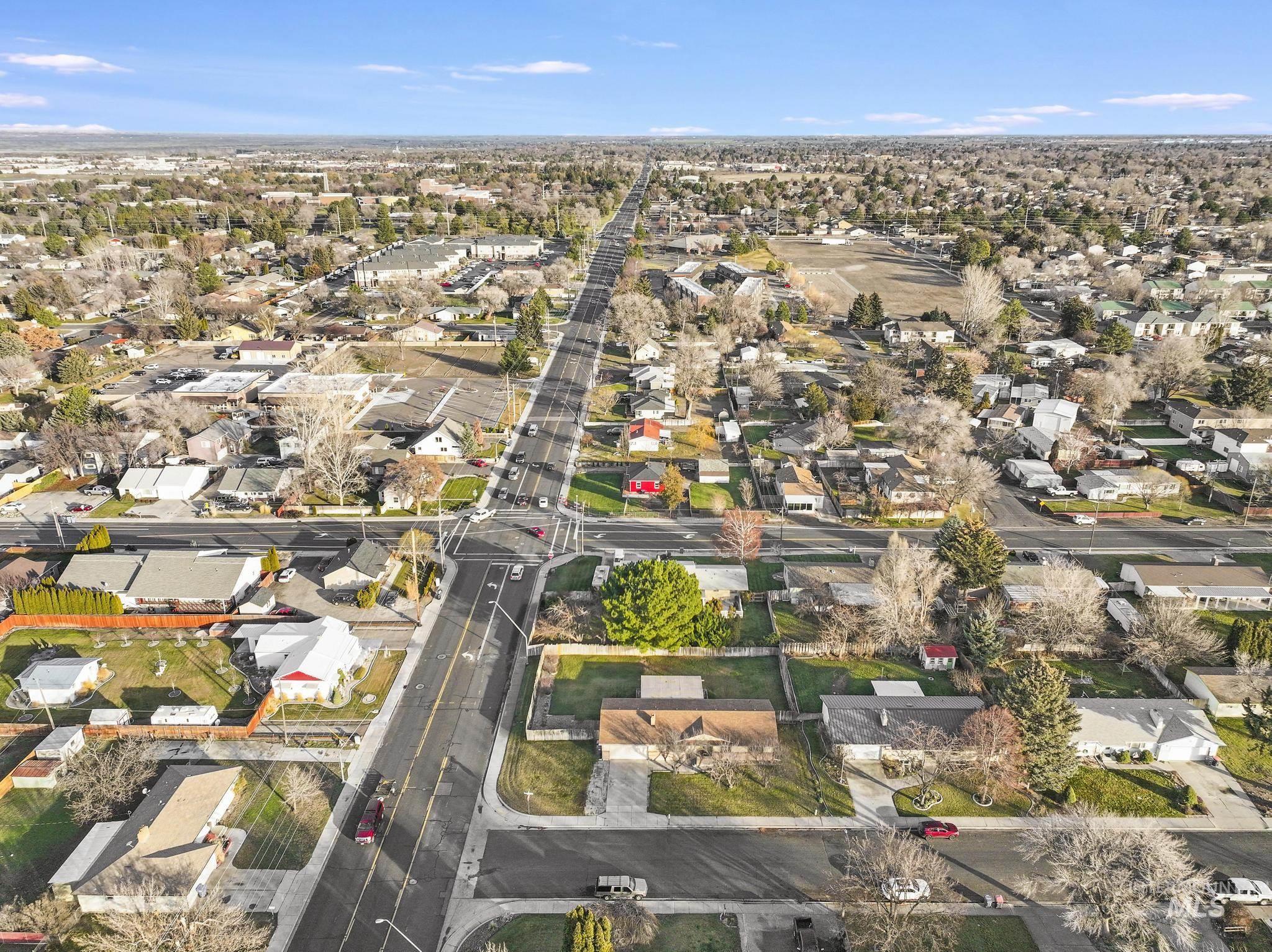 Aerial view of property and surrounding area with nearby suburban area