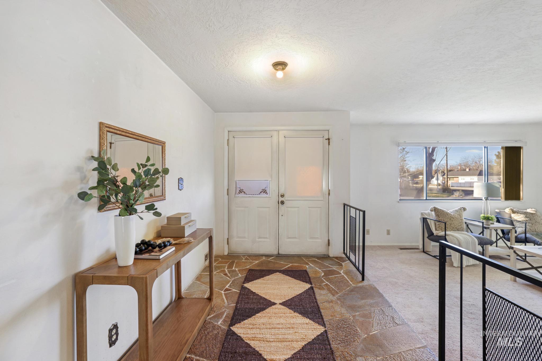 Foyer with a textured ceiling and carpet floors