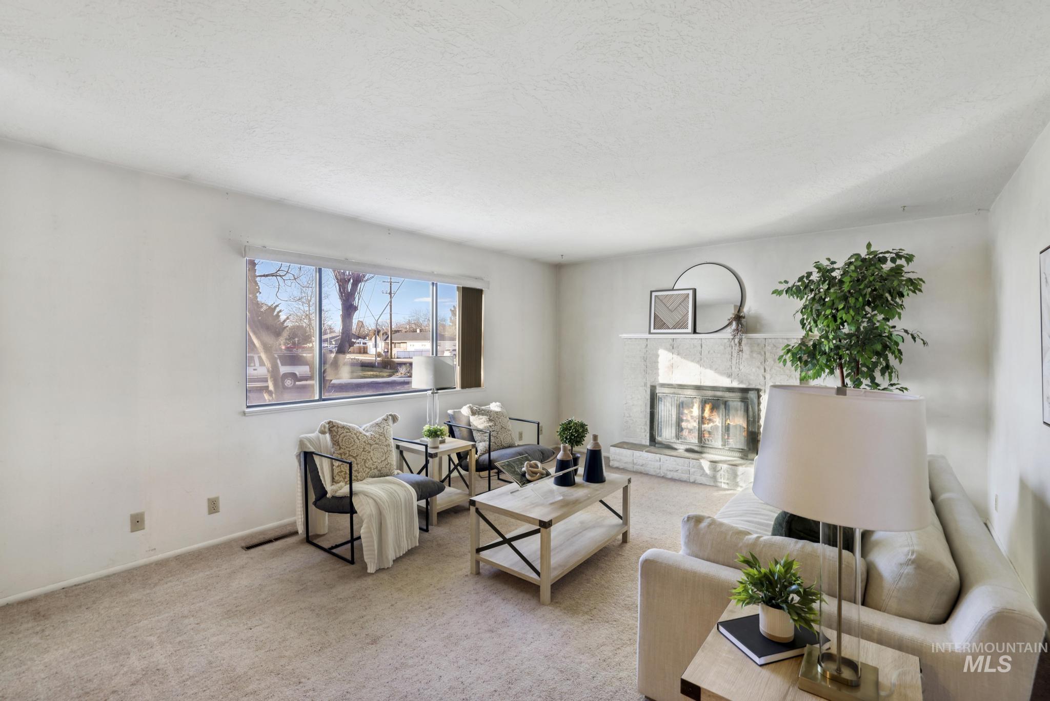 Carpeted living room featuring a fireplace and a textured ceiling