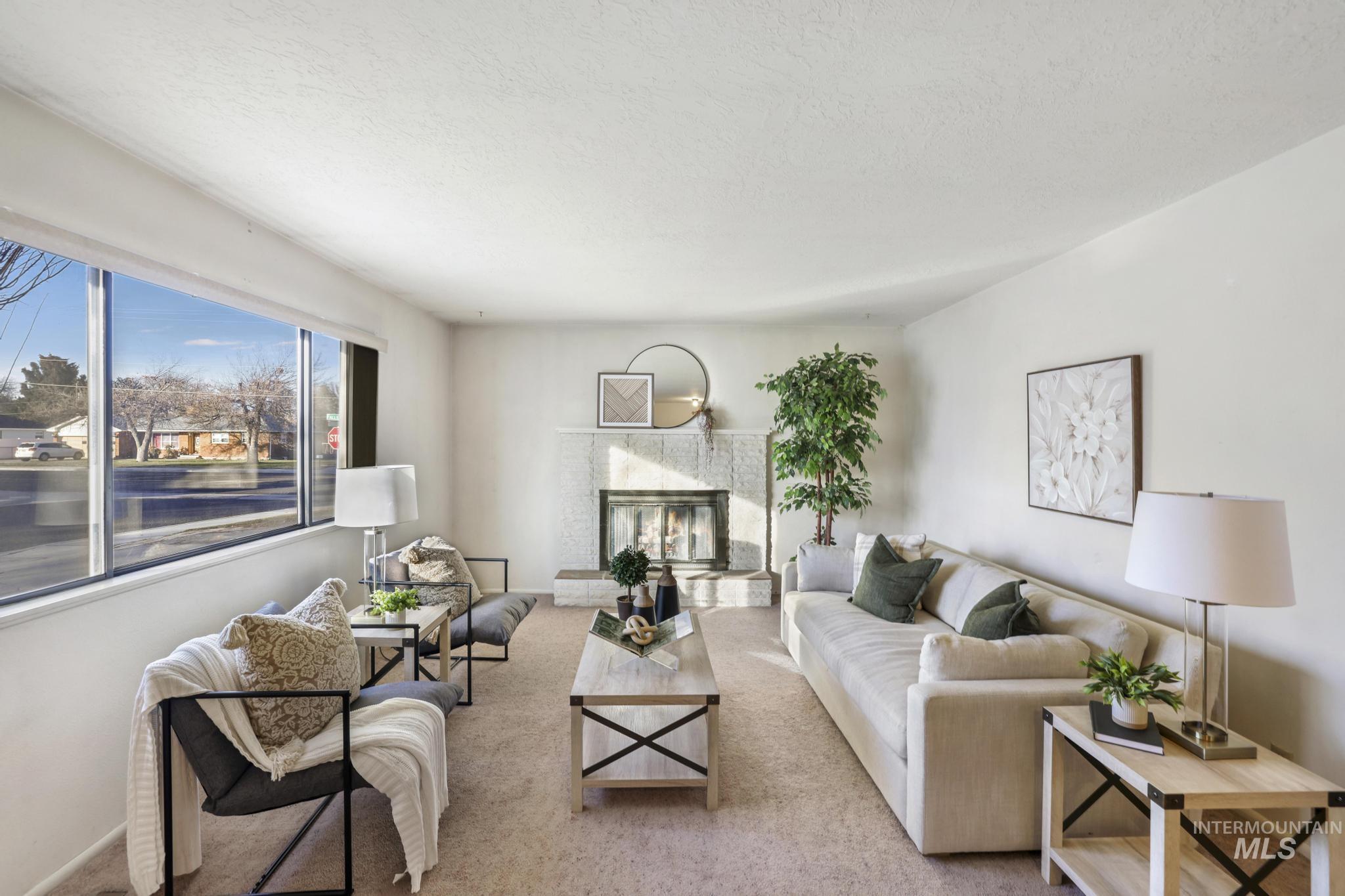 Living room featuring a glass covered fireplace, carpet floors, and a textured ceiling