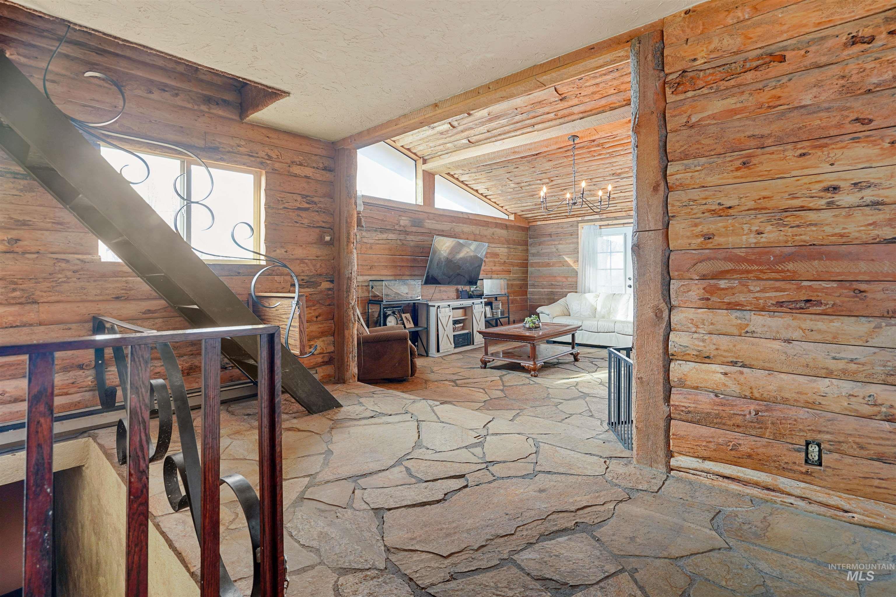 Interior space with rustic walls, plenty of natural light, and stone flooring