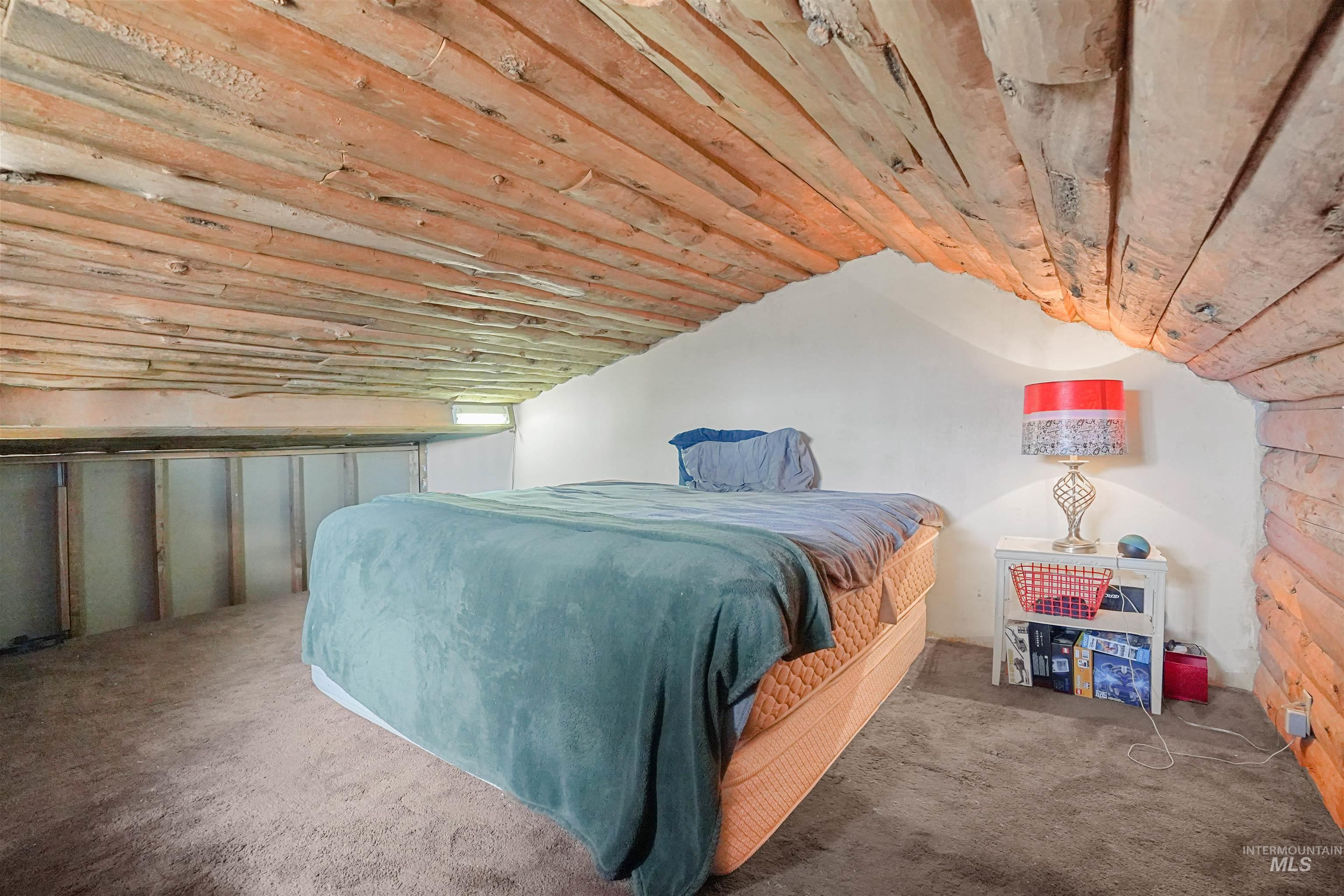 Bedroom featuring vaulted ceiling and carpet