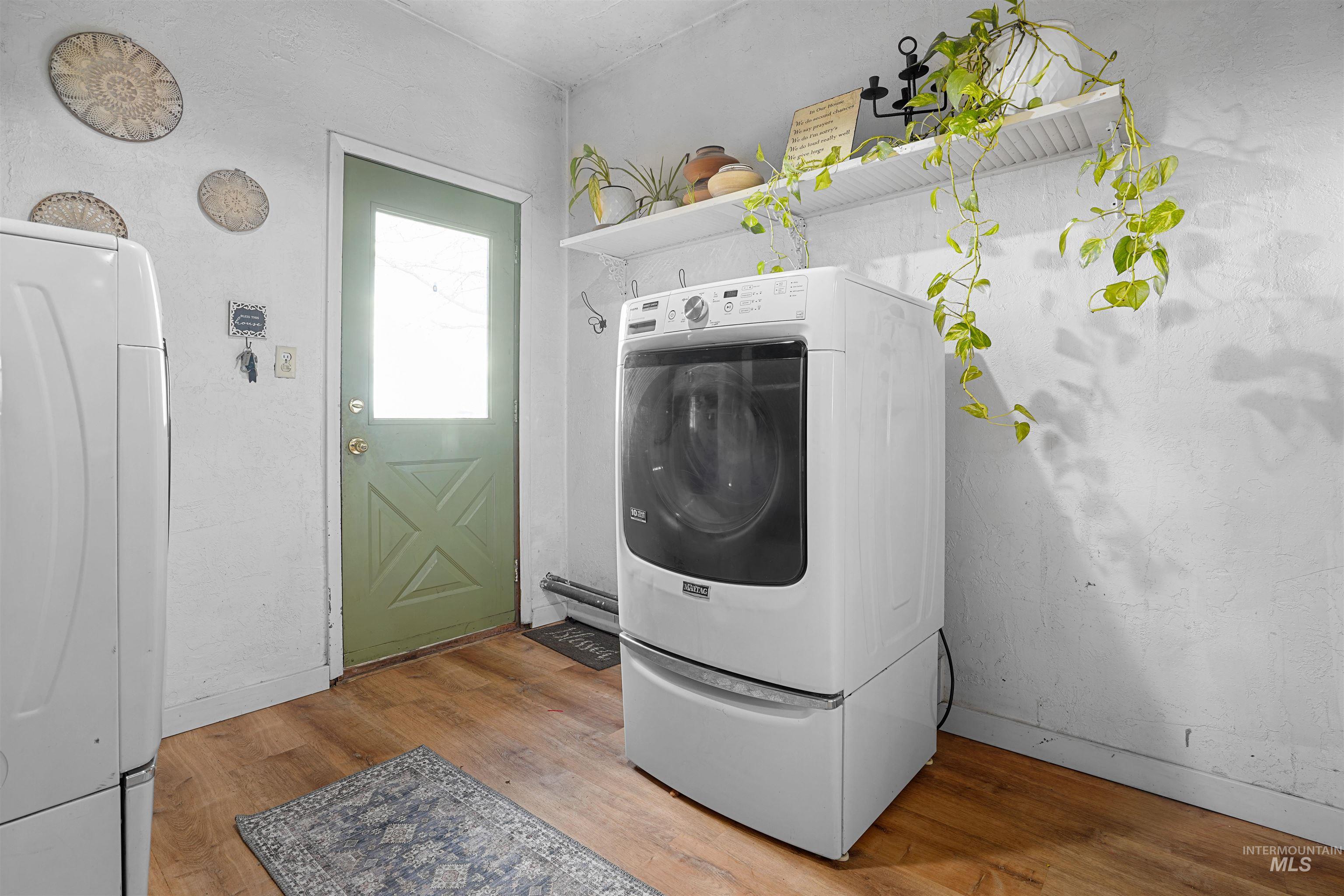 Laundry area with washer / clothes dryer and light wood finished floors