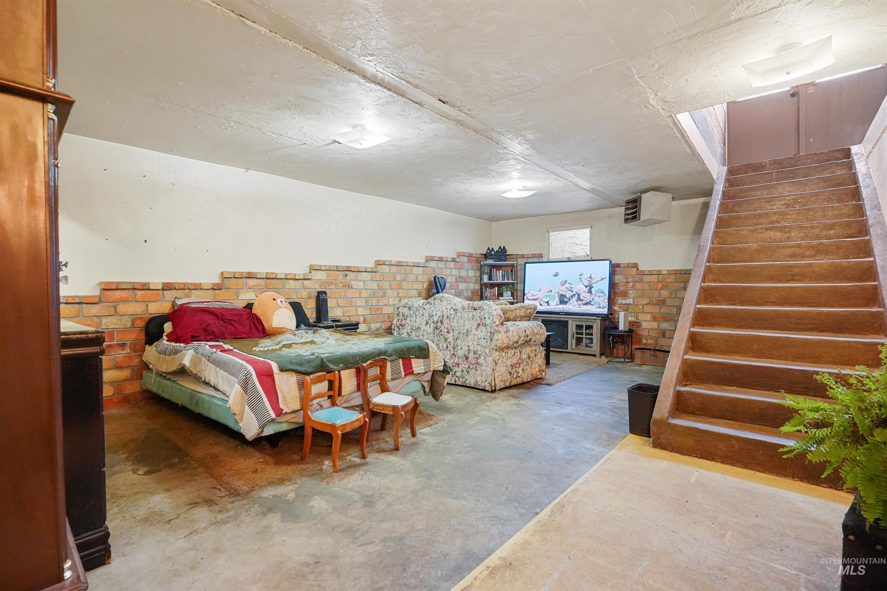 Bedroom featuring concrete flooring and a heating unit