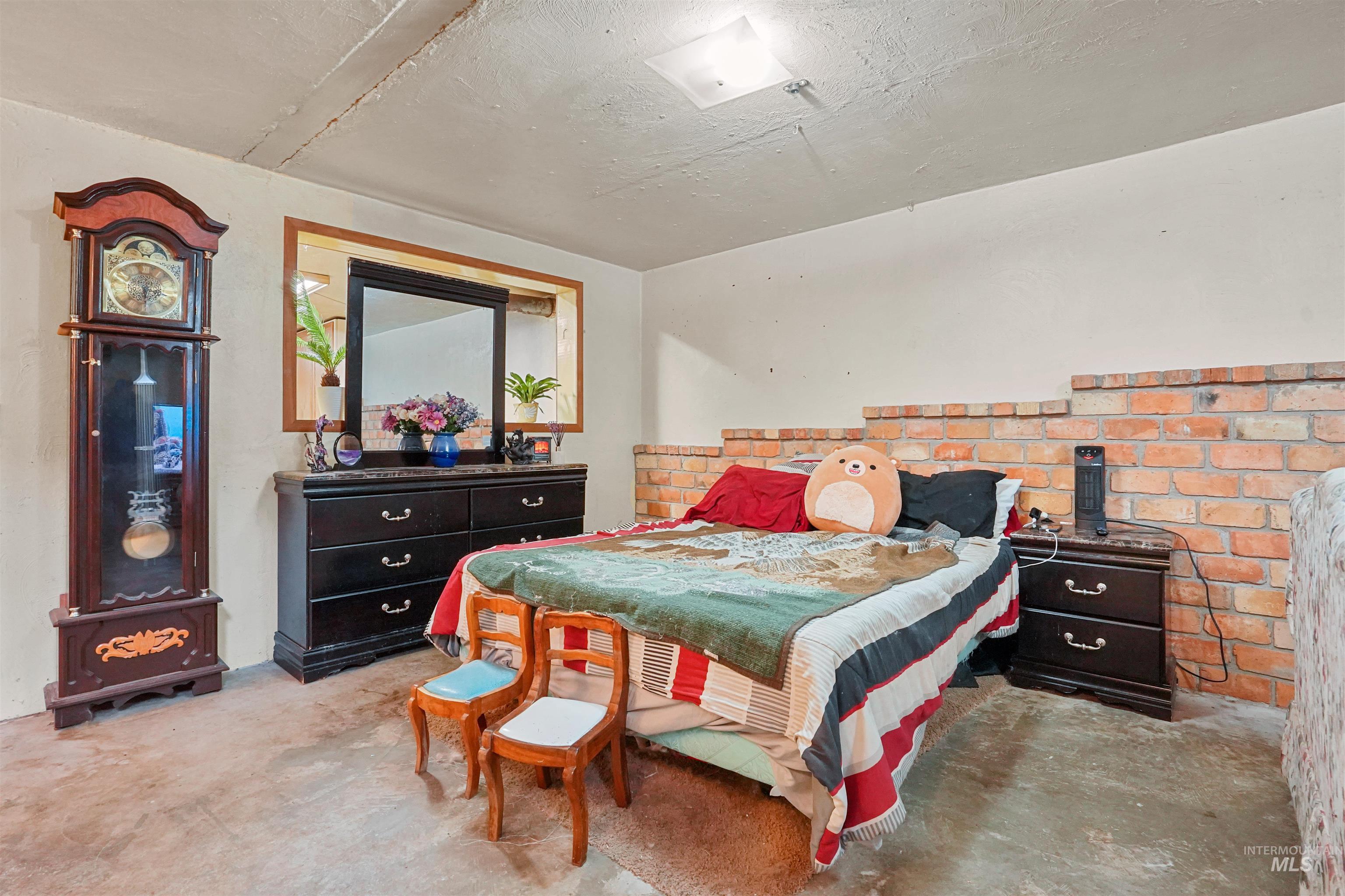 Bedroom with concrete flooring and a textured ceiling