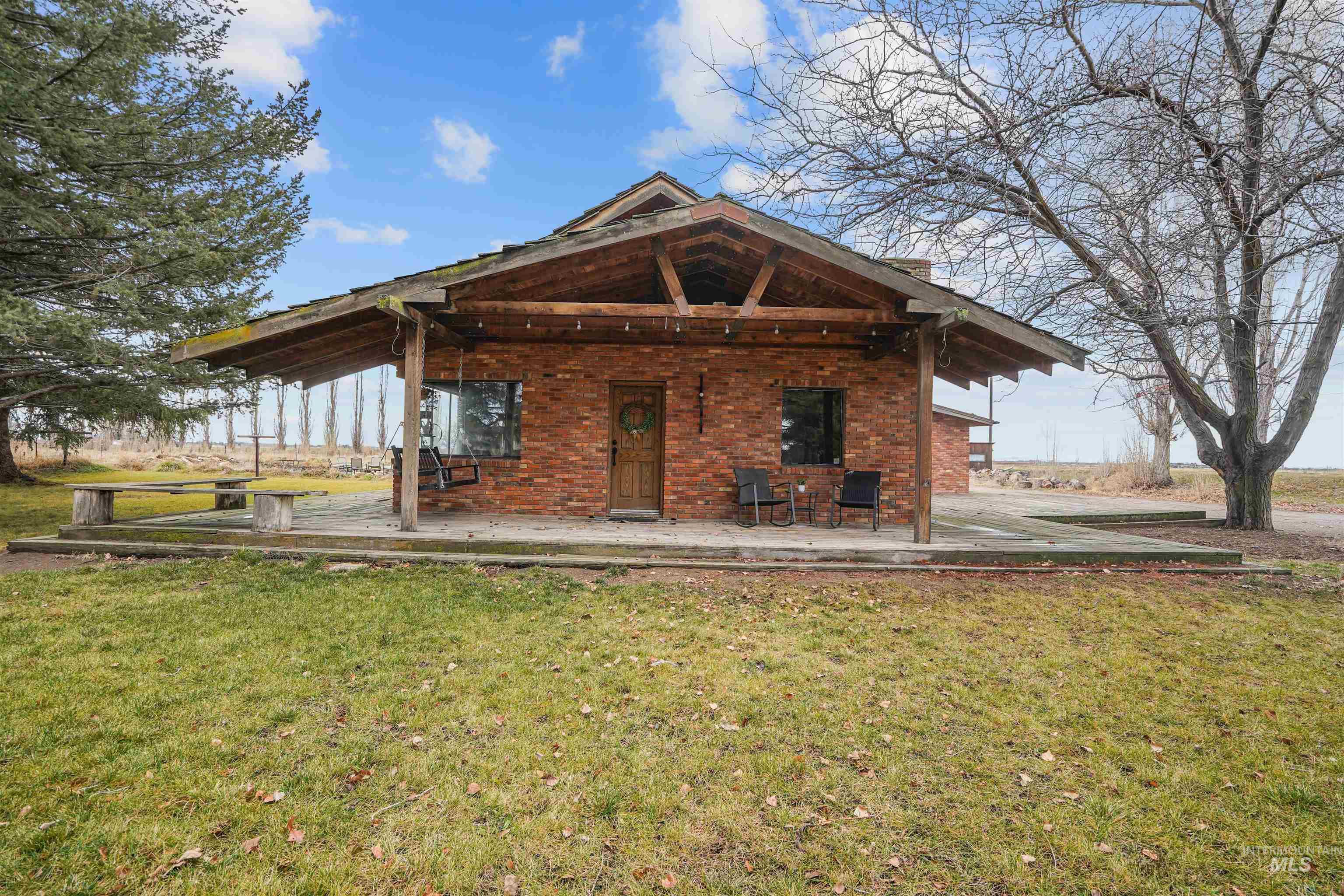 Back of property with a lawn, brick siding, and a chimney